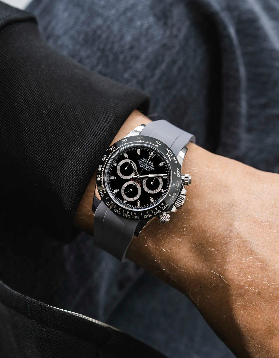 Grey integrated FKM rubber strap with original clasp on Rolex Daytona 116500 black dial ceramic bezel wrist shot classic smooth surface