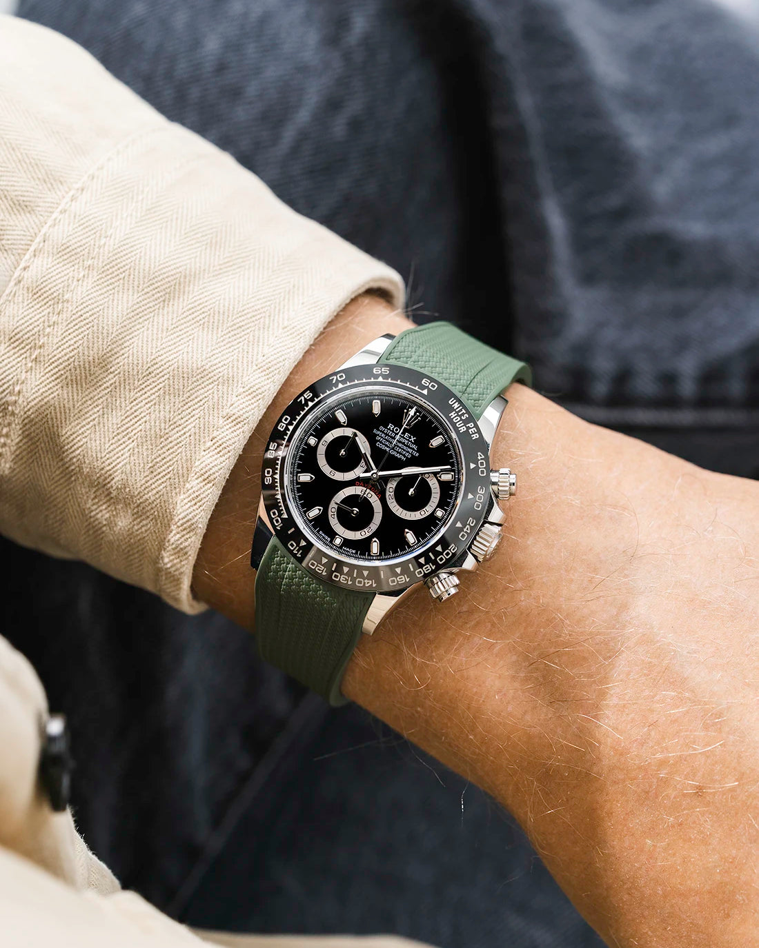 Military green integrated Vertech FKM rubber strap with original clasp on Rolex Daytona 116500 black dial ceramic bezel wrist shot textured surface