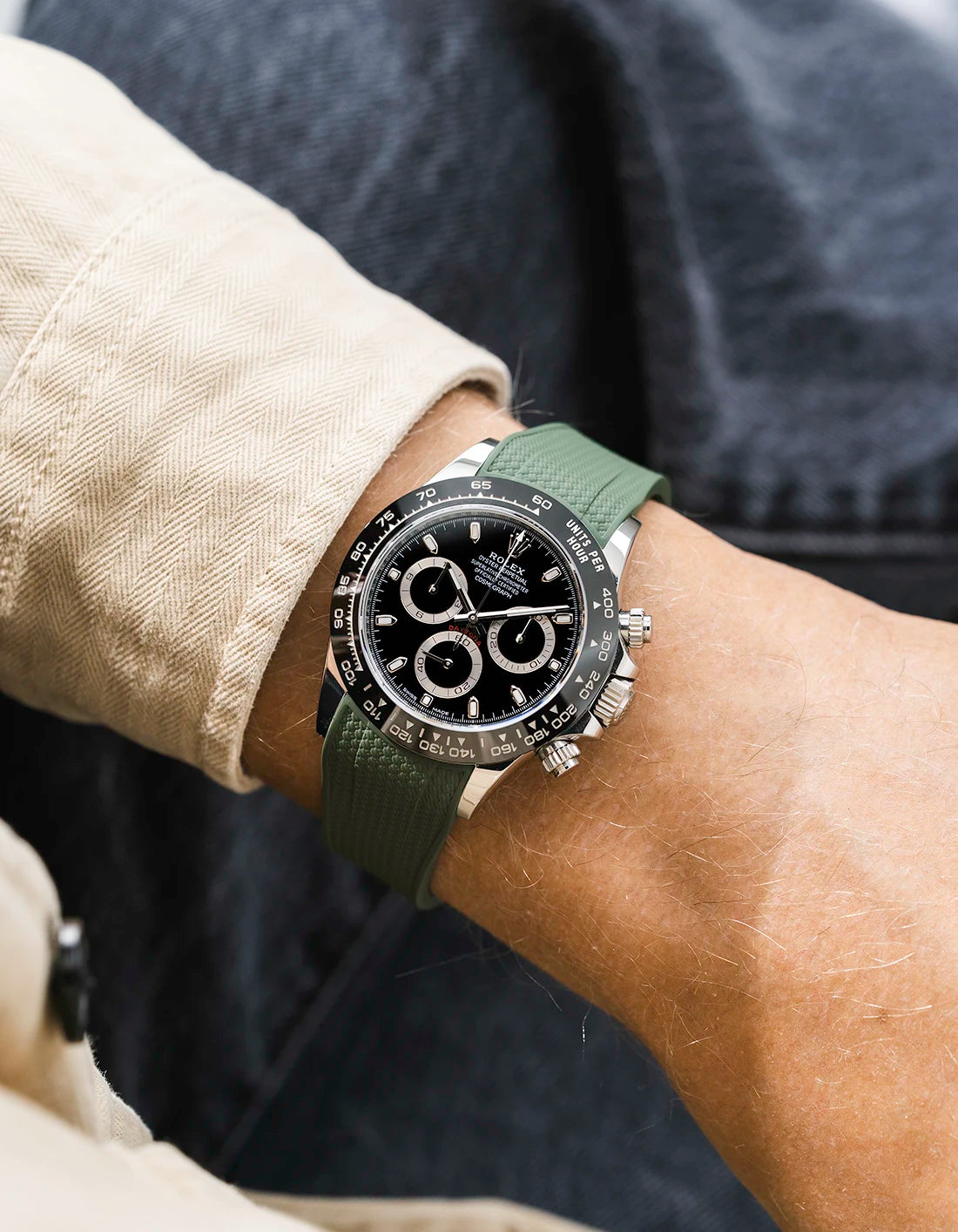 Military green integrated Vertech FKM rubber strap with original clasp on Rolex Daytona 116500 black dial ceramic bezel wrist shot textured surface
