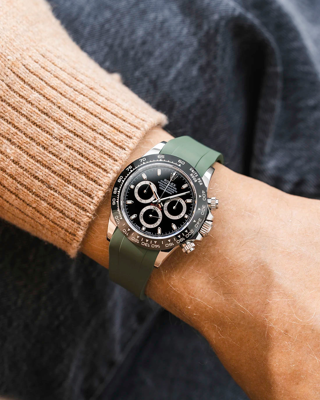 Military green integrated FKM rubber strap with original clasp on Rolex Daytona 116500 black dial ceramic bezel wrist shot classic smooth surface