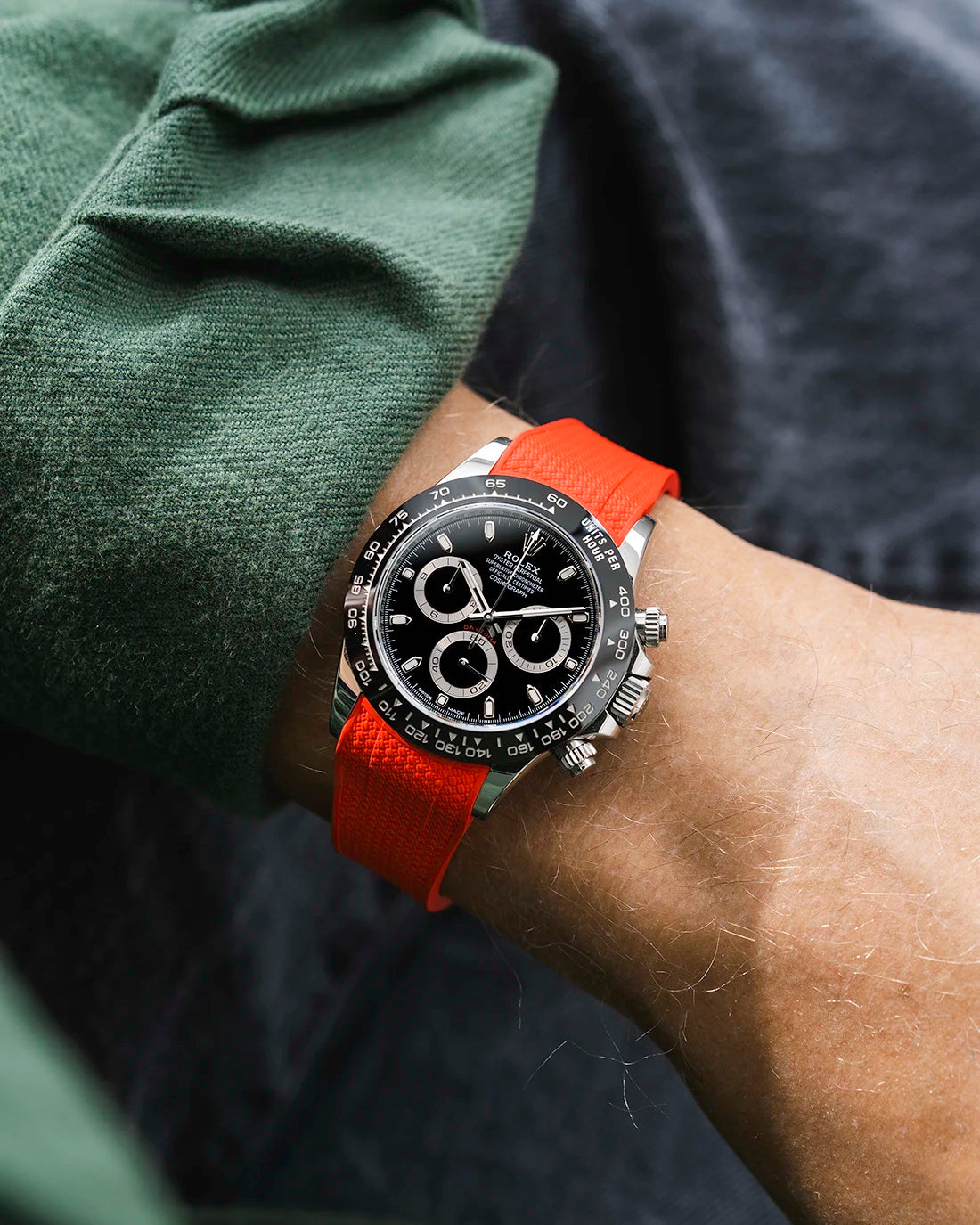 Red integrated Vertech FKM rubber strap with original clasp on Rolex Daytona 116500 black dial ceramic bezel wrist shot textured surface
