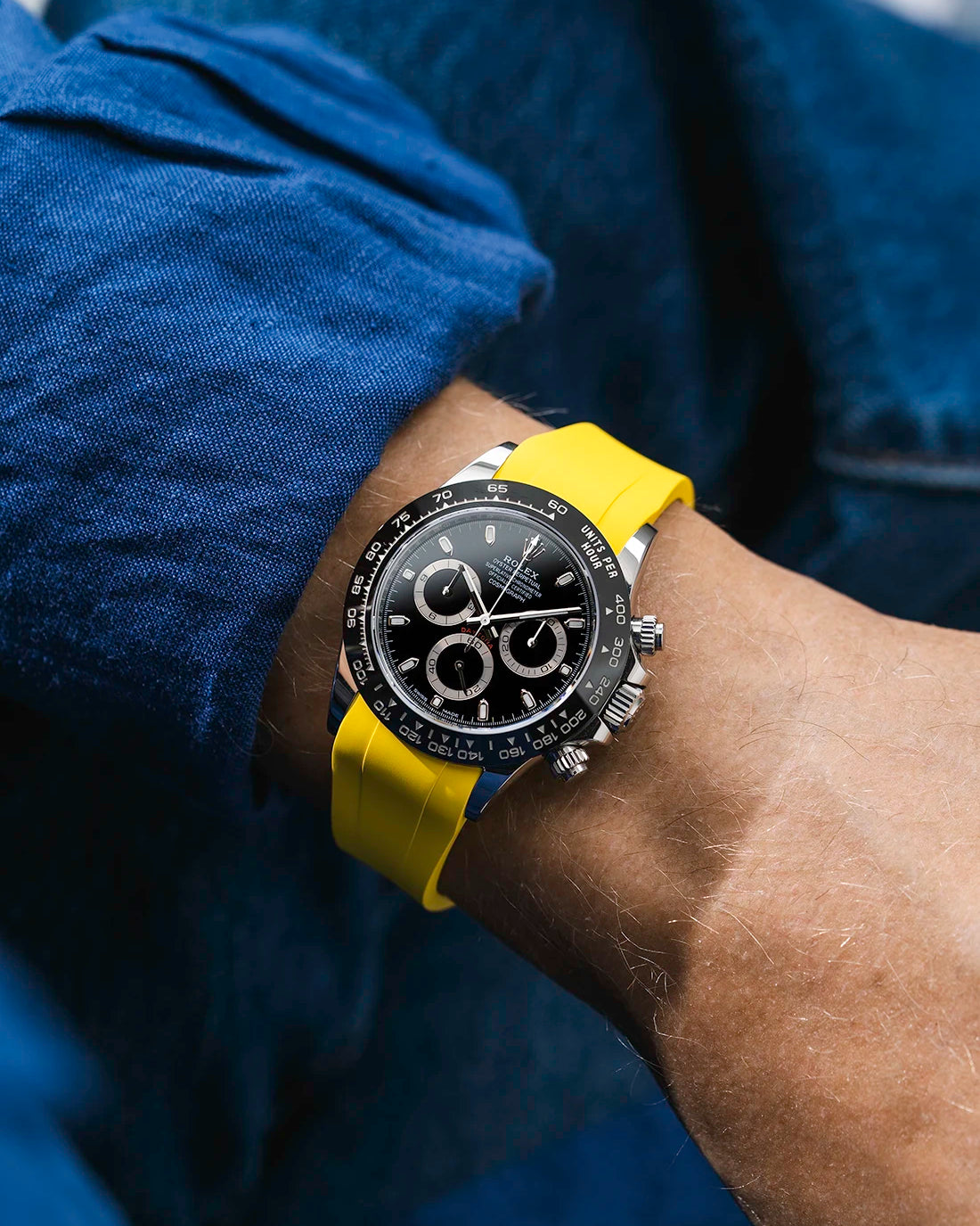 Yellow integrated FKM rubber strap with original clasp on Rolex Daytona 116500 black dial ceramic bezel wrist shot classic smooth surface