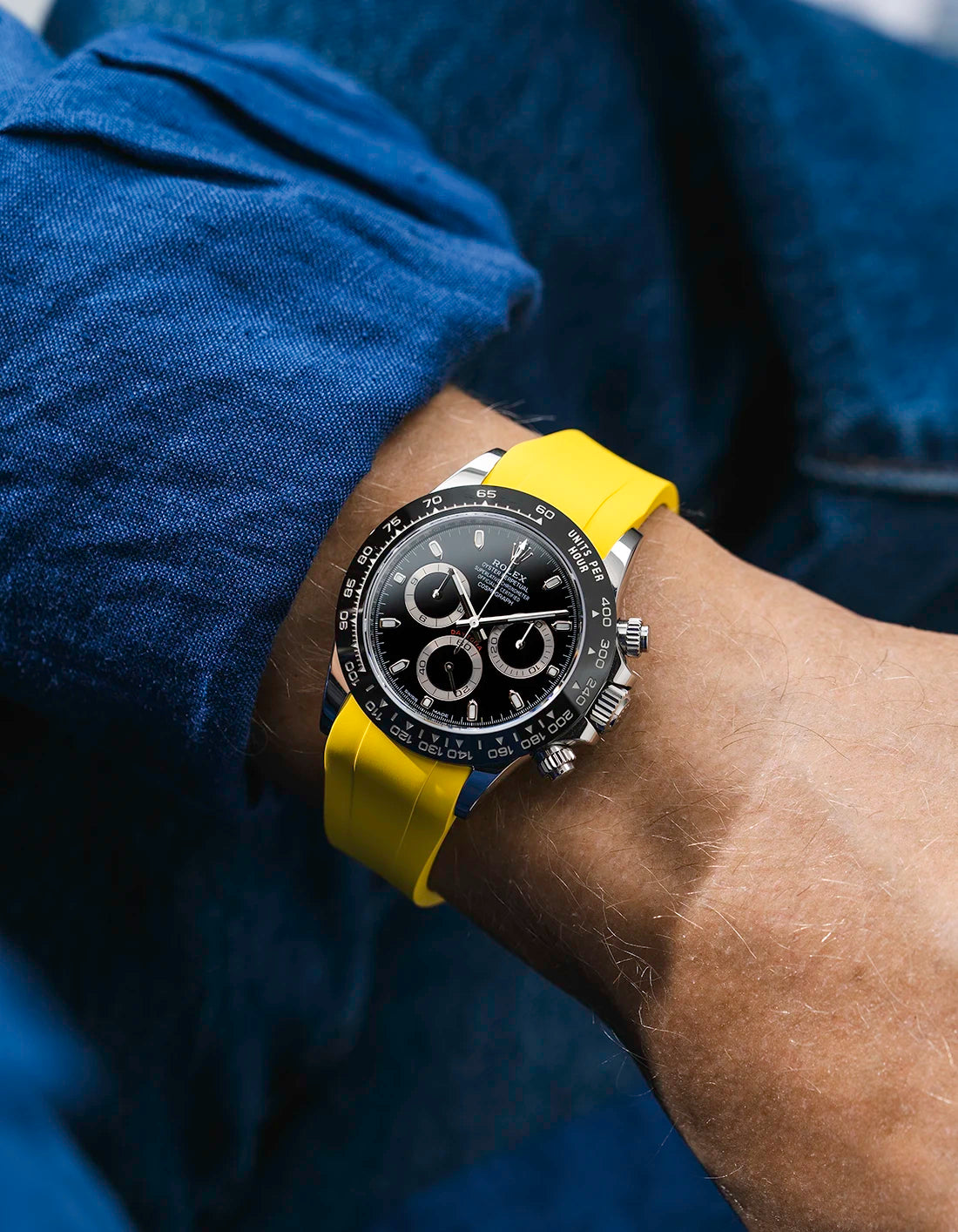 Yellow integrated FKM rubber strap with original clasp on Rolex Daytona 116500 black dial ceramic bezel wrist shot classic smooth surface