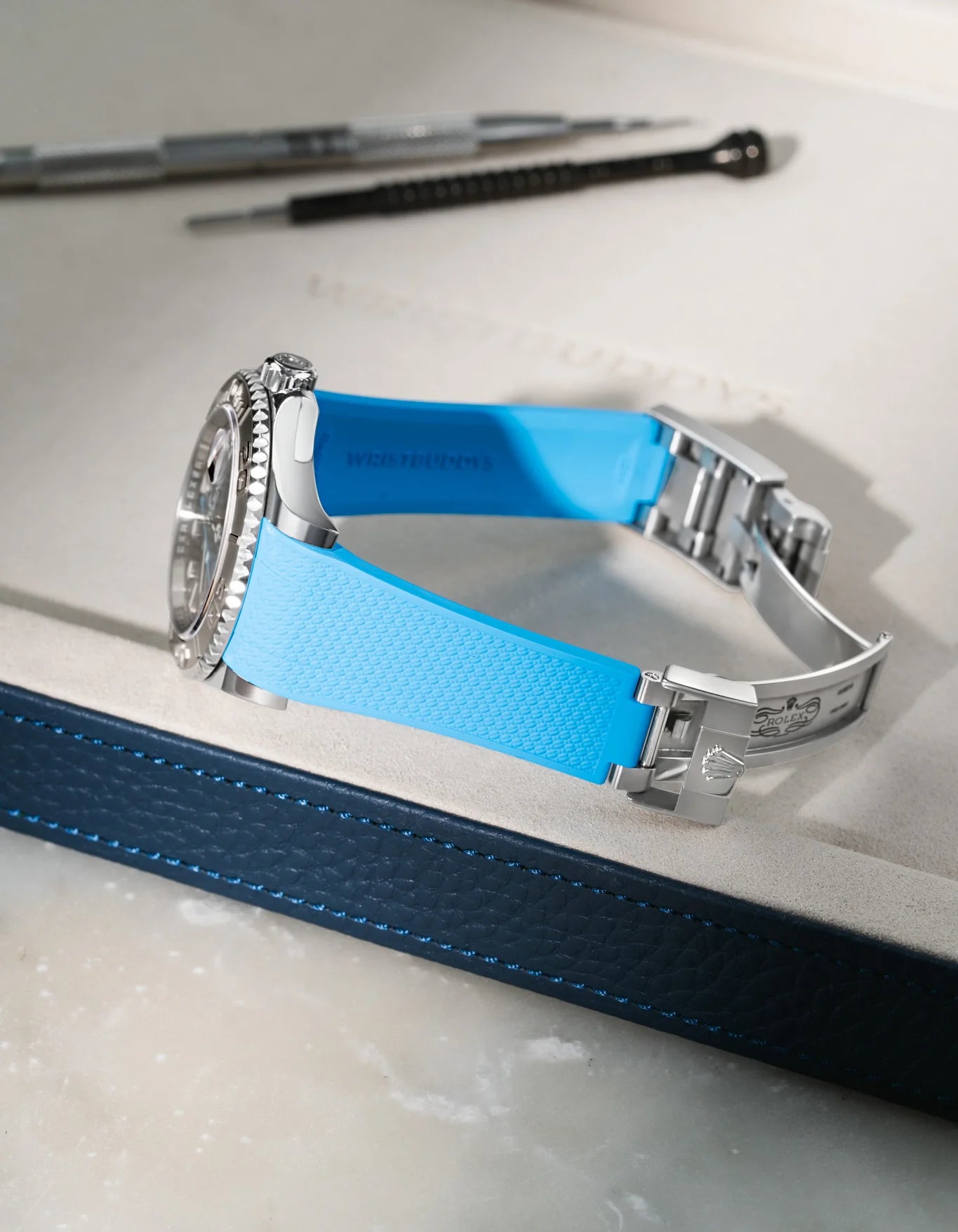 Capri Blue integrated FKM rubber watch strap for Rolex Yacht-Master 116622/126622, Vertech textured finish, fits original clasp on a grey valet tray.