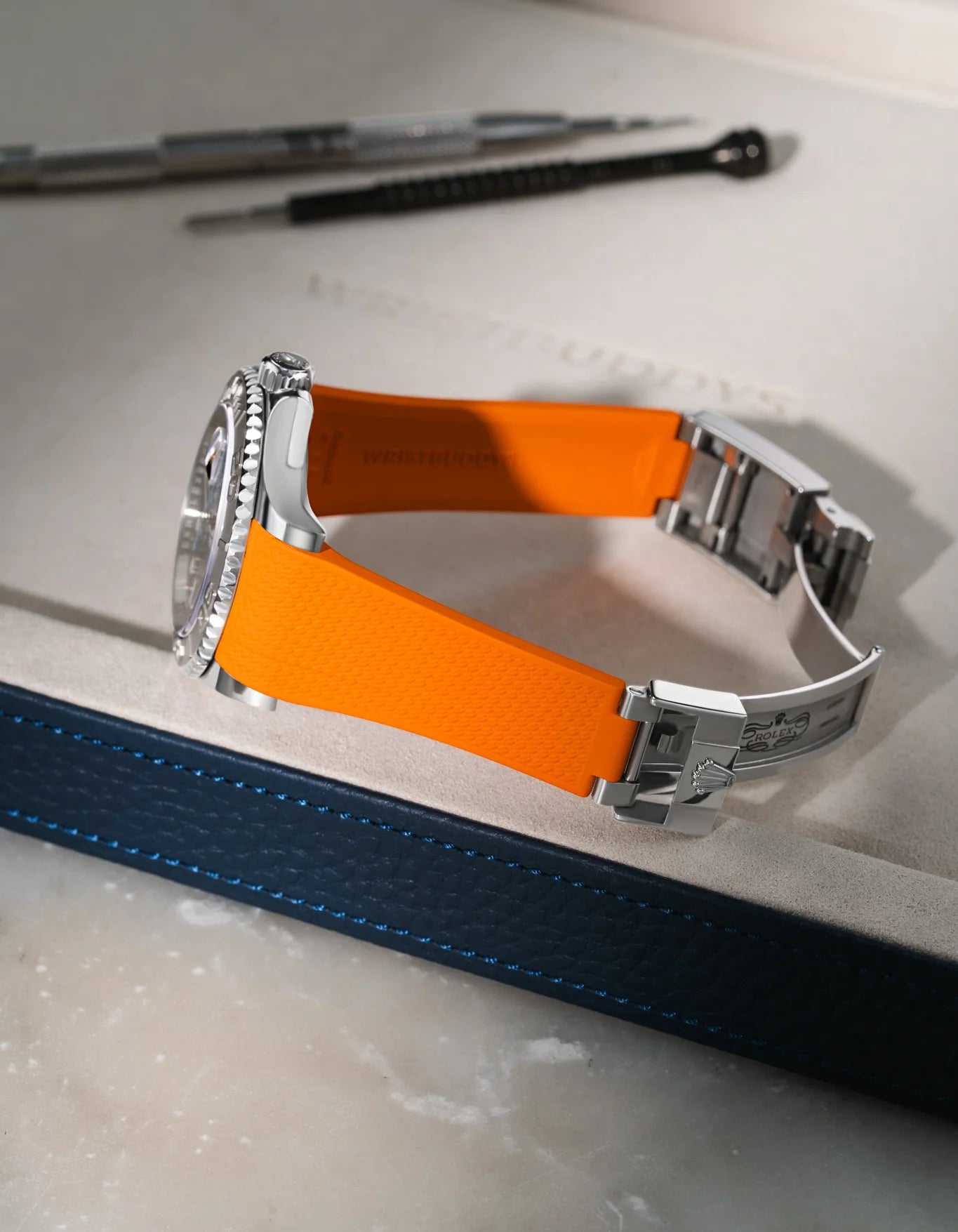 Orange Vertech FKM rubber strap for Rolex Yacht-Master 116622 & 126622, seamless integration with original oysterlock clasp, resting on a grey tray.