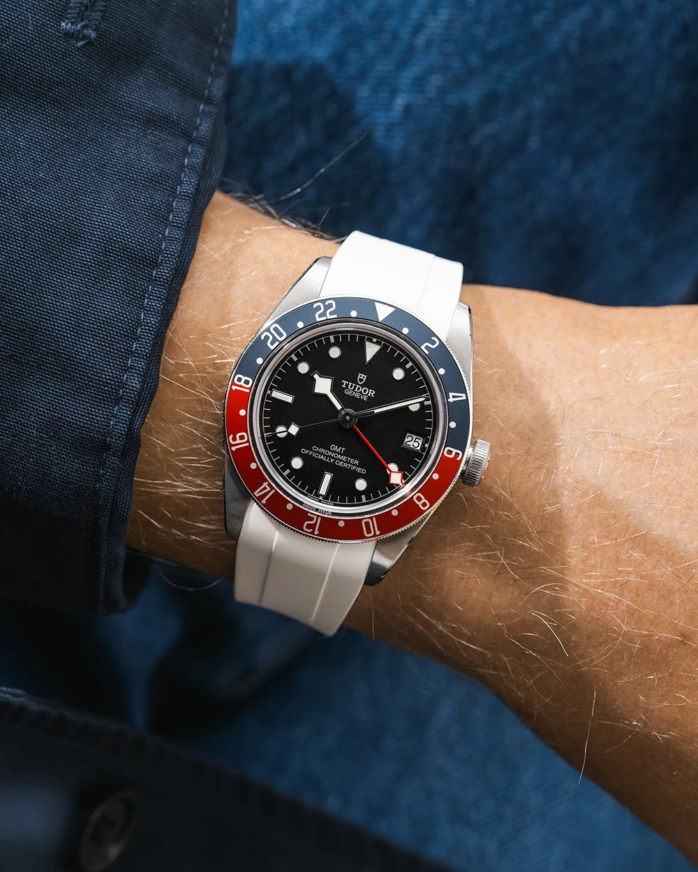 Tudor GMT watch on a person's wrist with a white FKM rubber watch strap from Wristbuddys and red & blue accents on the bezel