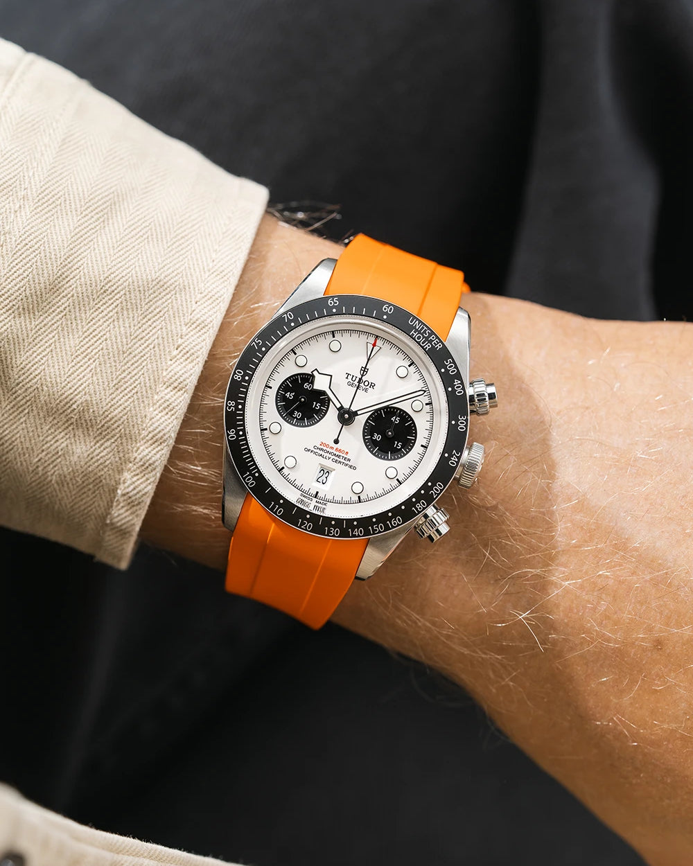 Tudor Chrono watch on a person's wrist with a orange FKM rubber watch strap from Wristbuddys and black accents on the bezel