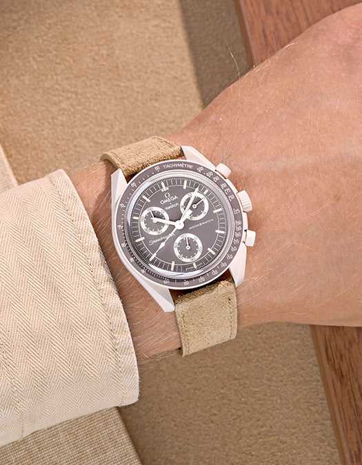Omega X Swatch Mission on Earth – Desert with Beige suede leather strap worn on wrist – styled shot with light tones