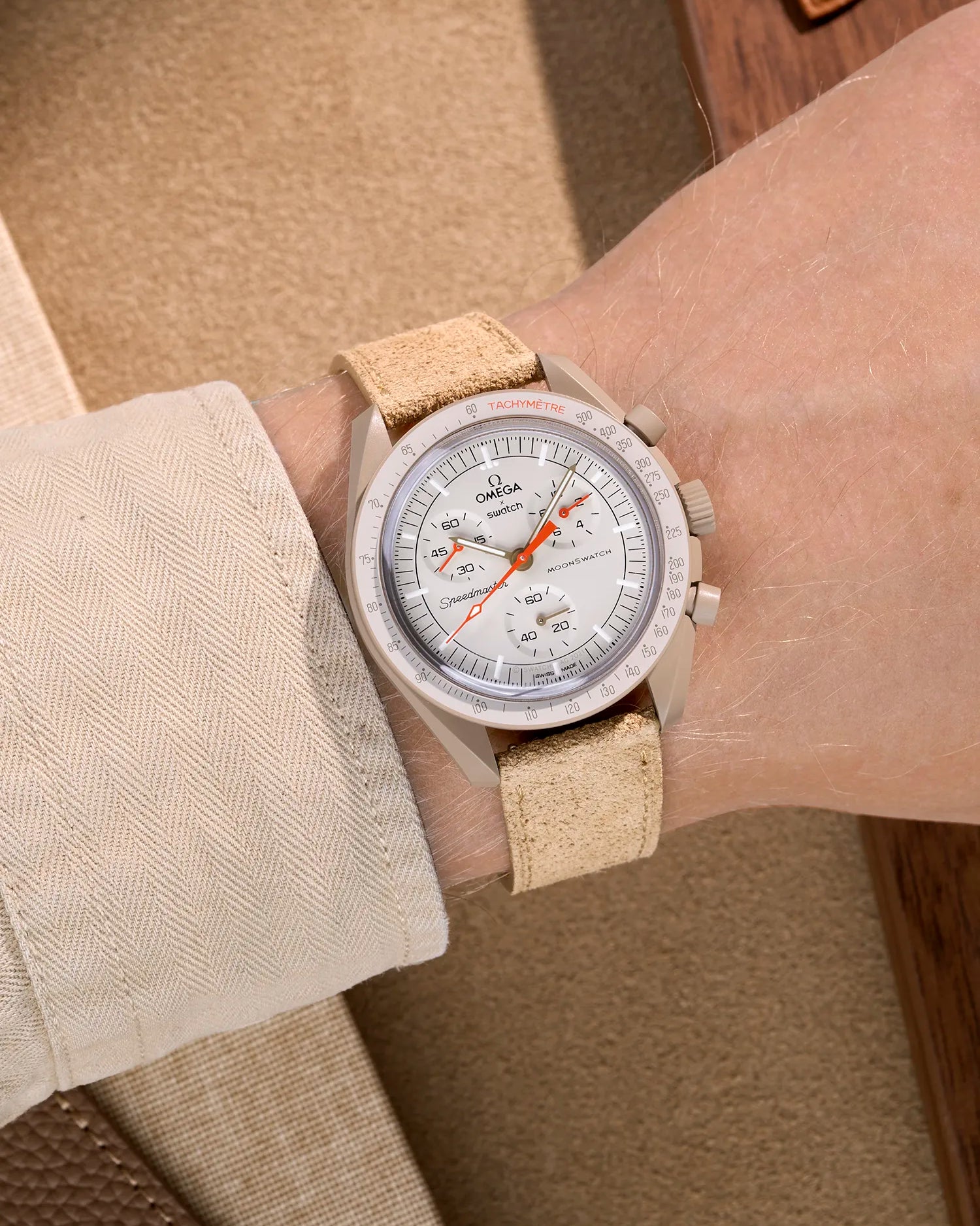 Omega X Swatch Mission to Jupiter with Beige suede leather strap worn on wrist – styled shot in earthy neutral tones