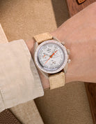 Omega X Swatch Mission to Jupiter with Beige suede leather strap worn on wrist – styled shot in earthy neutral tones