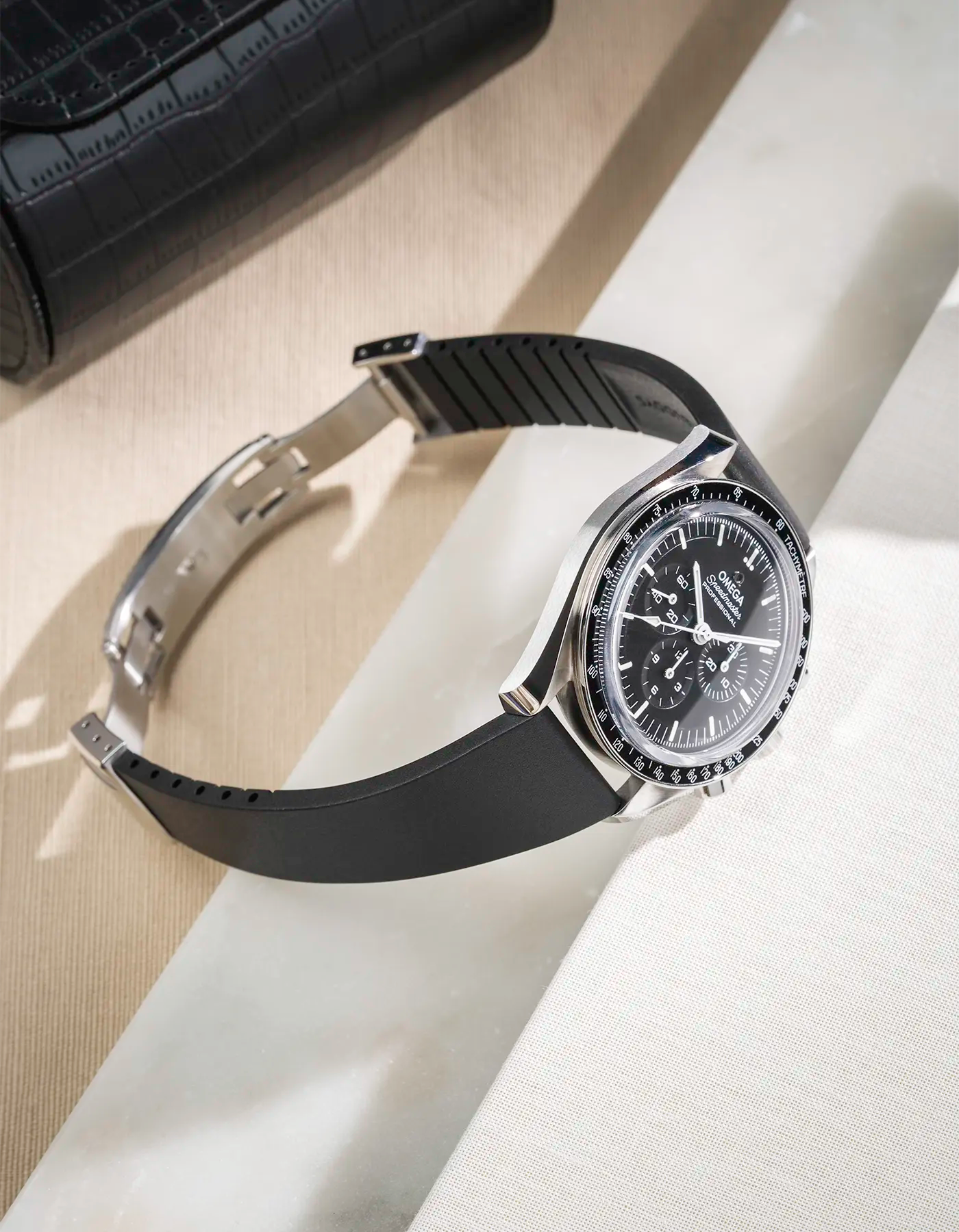 Watch with black CTS FKM rubber strap 19-22 mm lying on a table showing how it fits