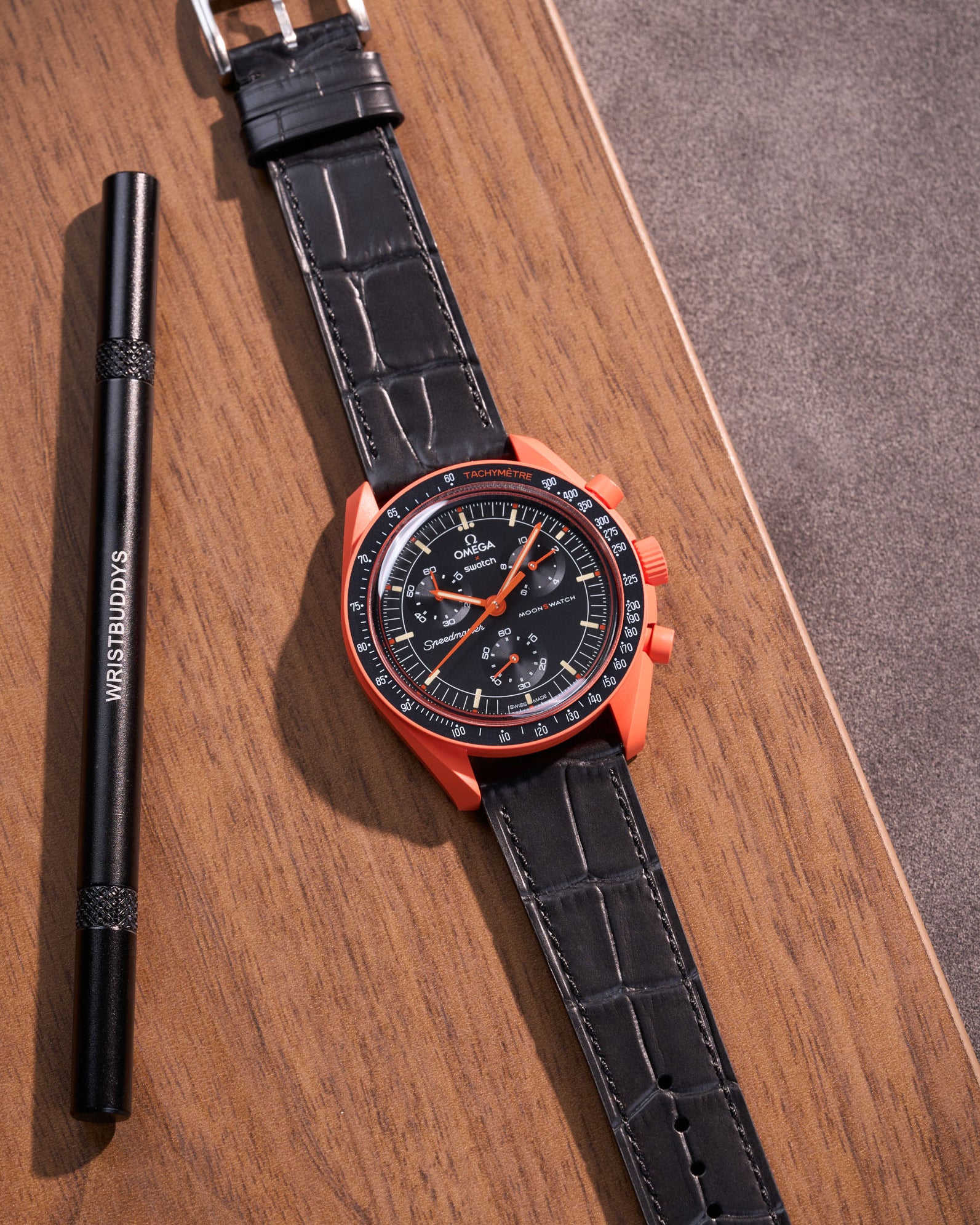 Flat lay of black embossed alligator leather strap for Omega x Swatch MoonSwatch mission on Earth Lava