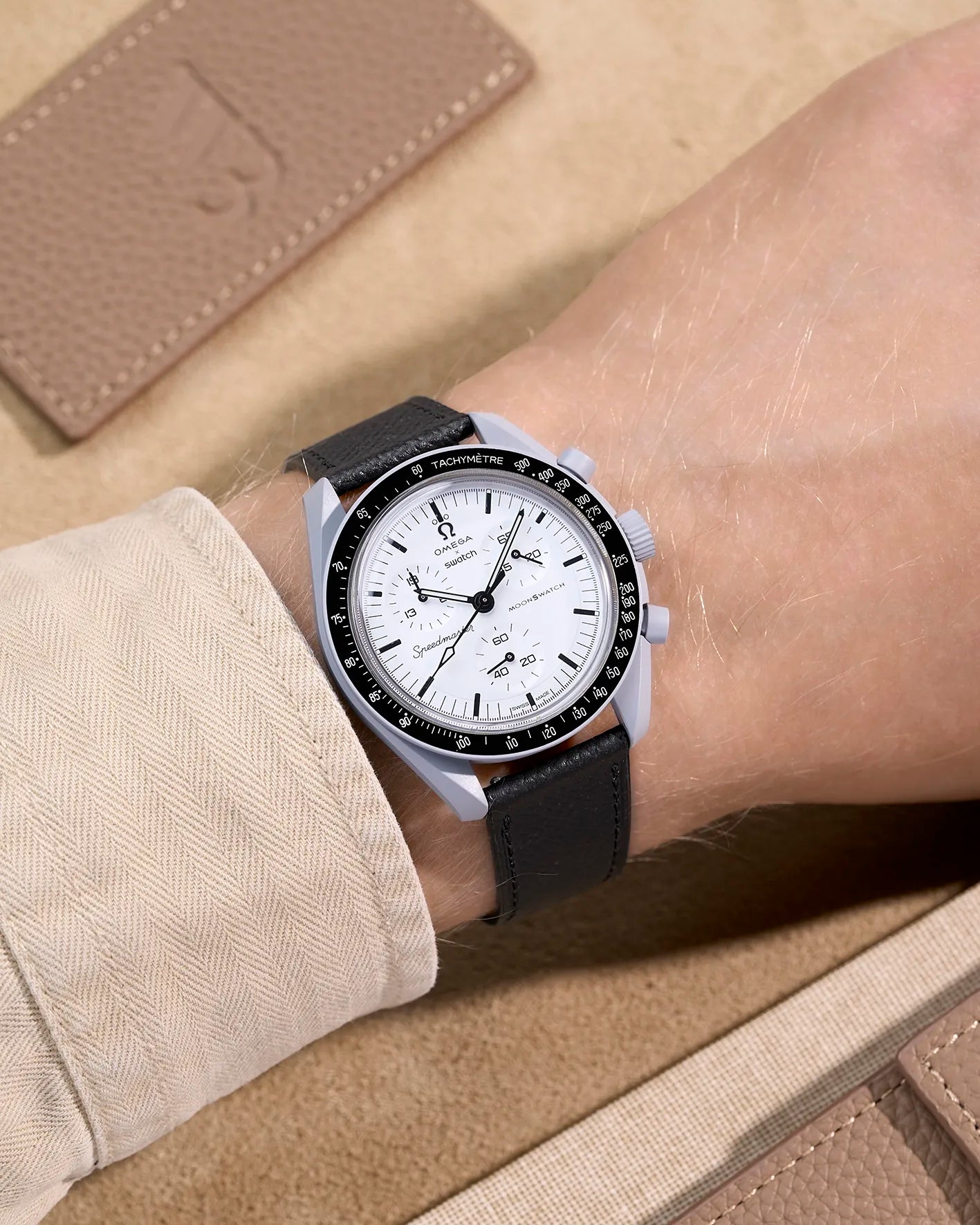 Black Epsom leather strap on Omega X Swatch MoonSwatch 1965 | elegant watch band worn with off-white sleeve