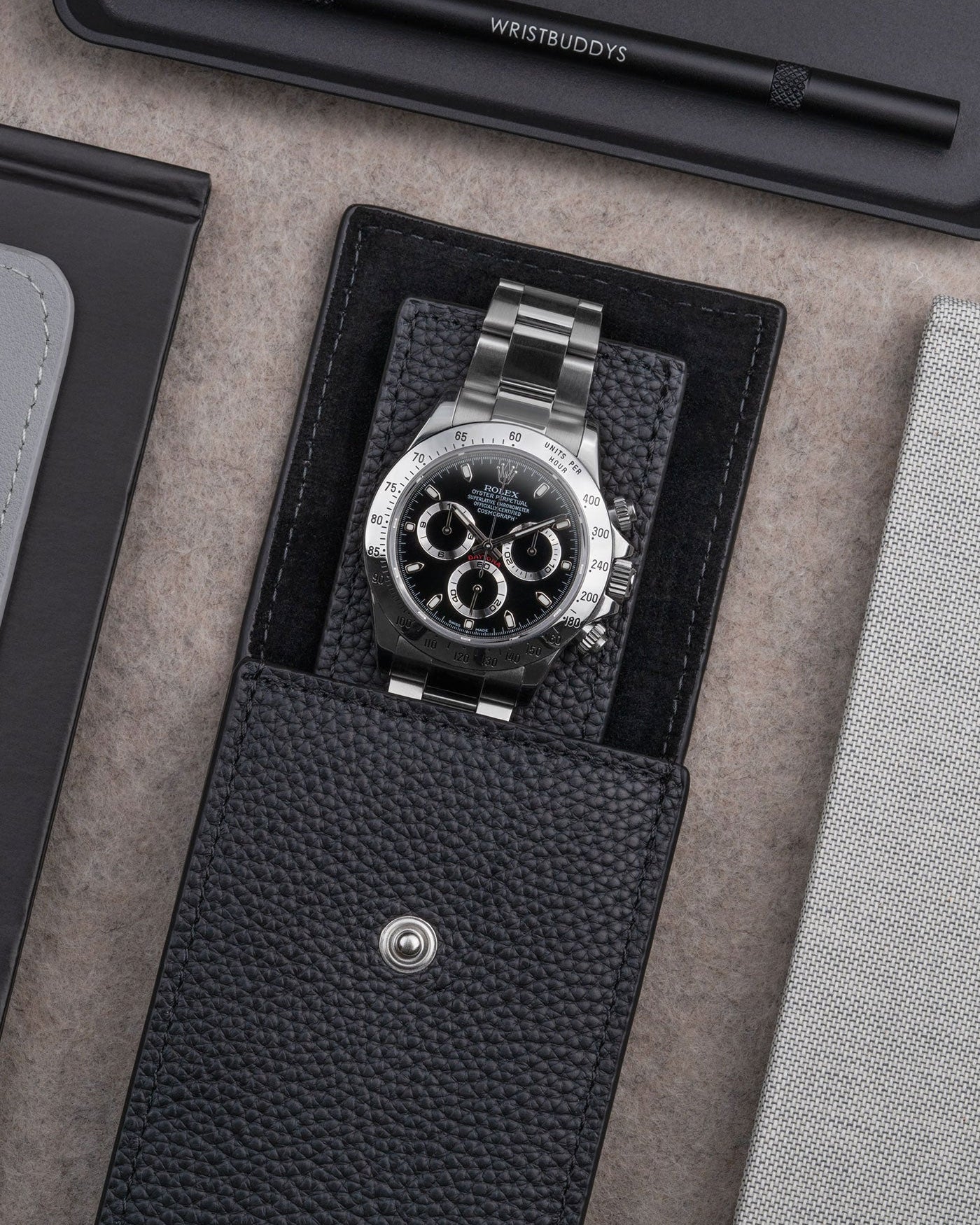 Black leather watch pouch by Wristbuddys with Rolex Daytona placed inside open case – premium leather storage for luxury watches