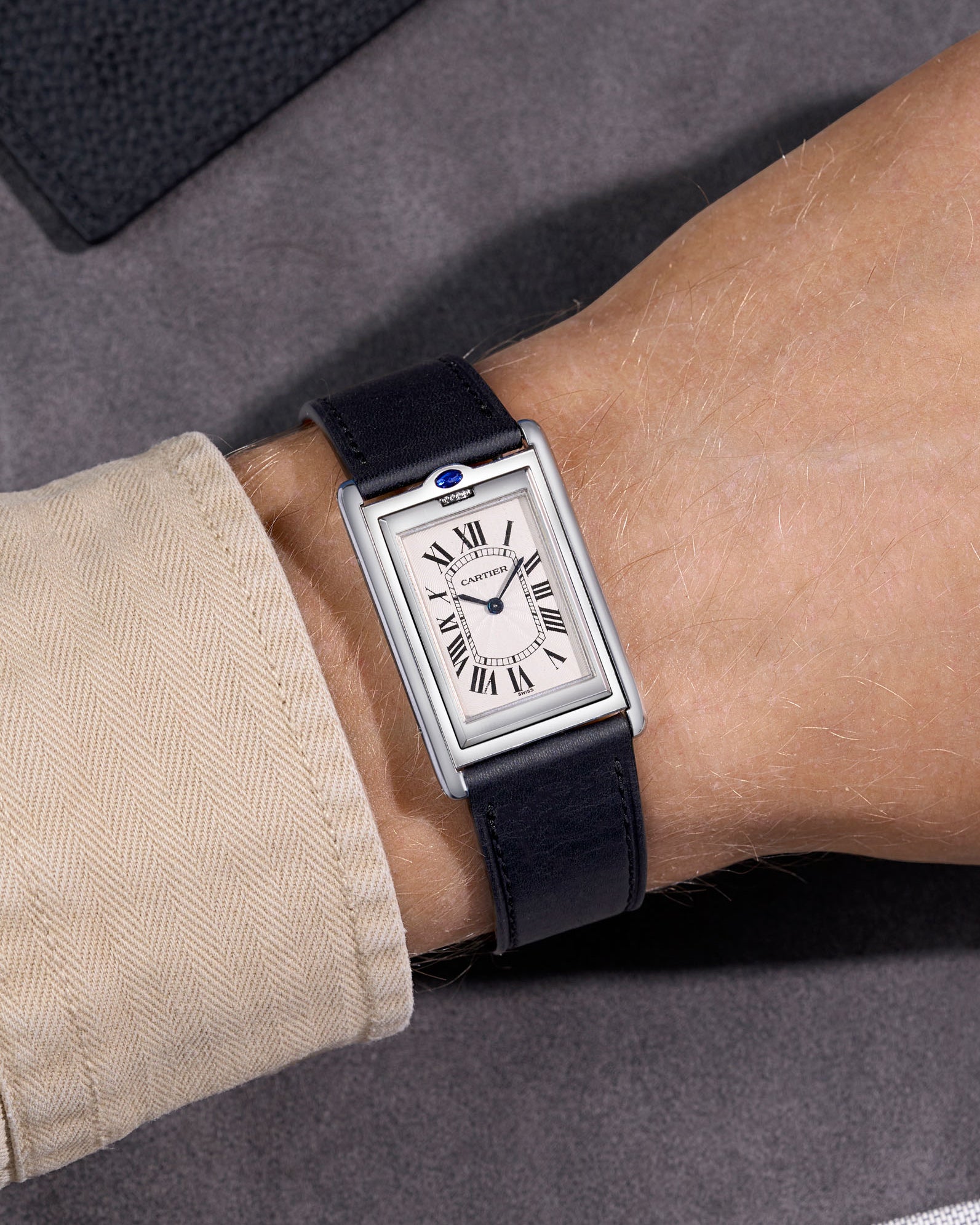 Cartier Basculante on a black cowhide leather watch strap. Handmade in Italy with a sude background.