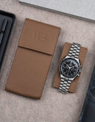Brown leather watch pouch by Wristbuddys with Omega Speedmaster placed alongside closed case – stylish leather travel pouch for watches