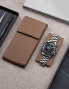 Brown leather watch pouch by Wristbuddys with Omega Speedmaster resting on pouch lid – luxury travel case for watches