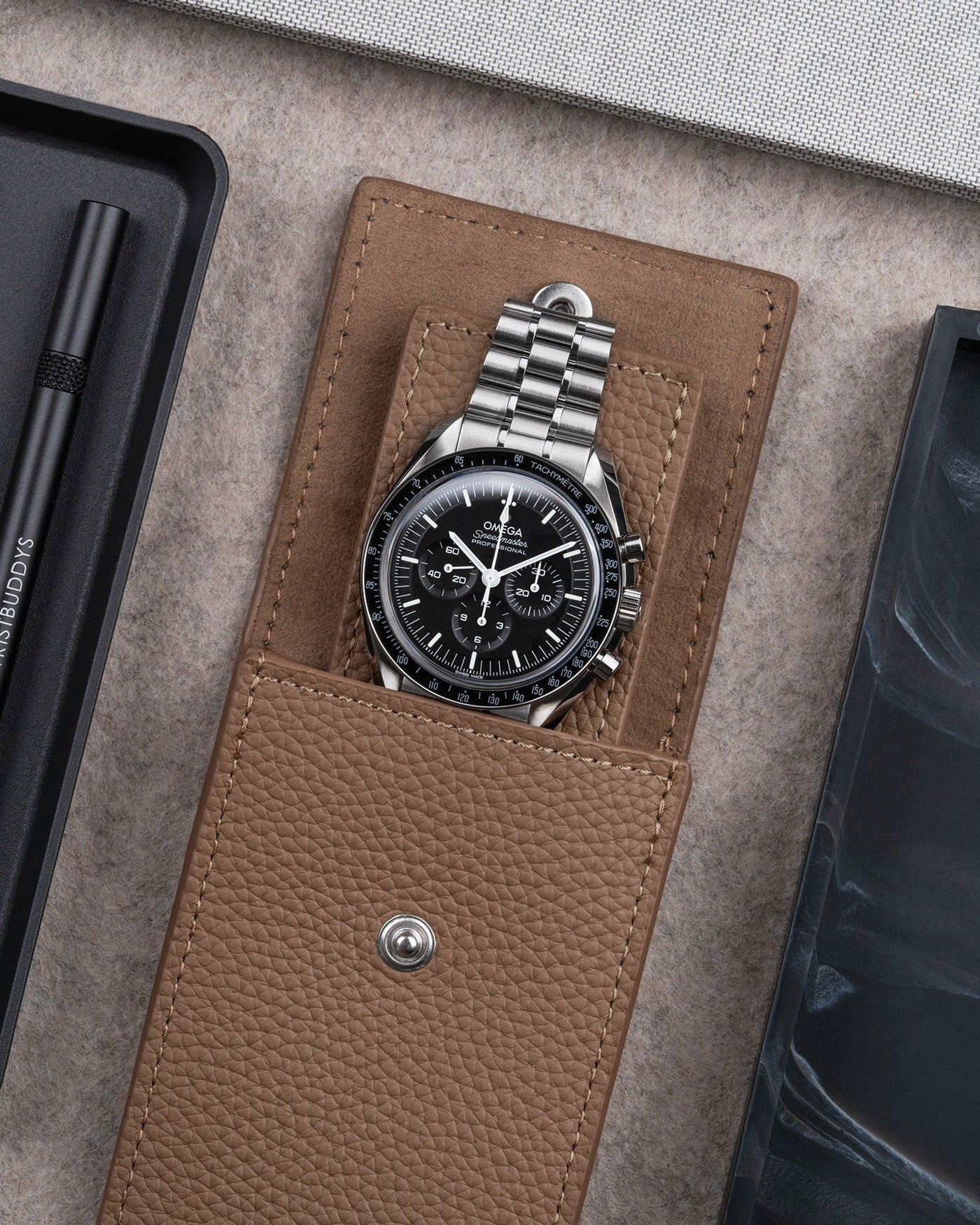 Brown leather watch pouch by Wristbuddys with Omega Speedmaster inside open case – premium leather watch storage accessory