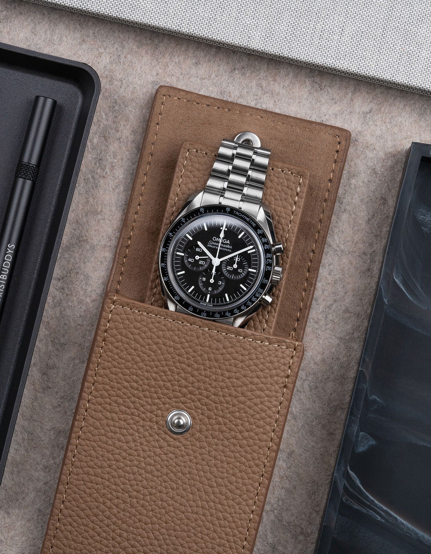 Brown leather watch pouch by Wristbuddys with Omega Speedmaster inside open case – premium leather watch storage accessory