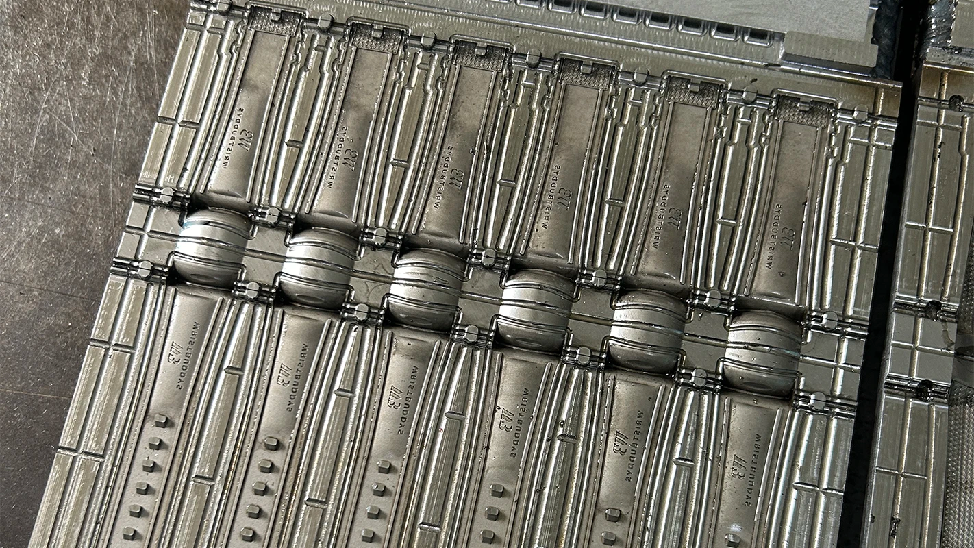 Close-up of stainless steel mold used in Wristbuddys rubber strap production, maintained for precision and durability