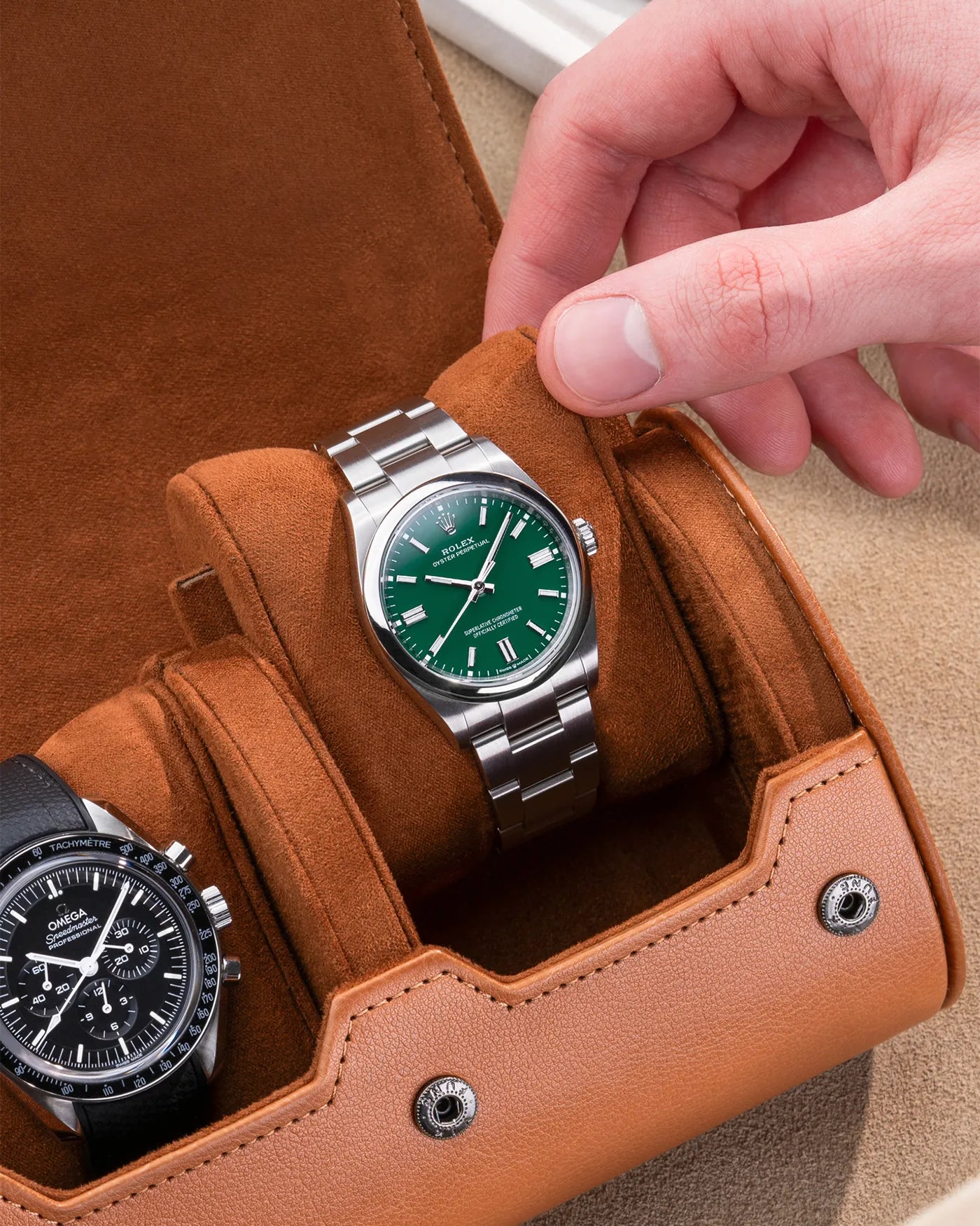 Brown watch roll with Sliding System, featuring a Rolex Oyster Perpetual with a green dial and an Omega Speedmaster, securely placed on soft suede sliding cushions for elegant and safe storage.
