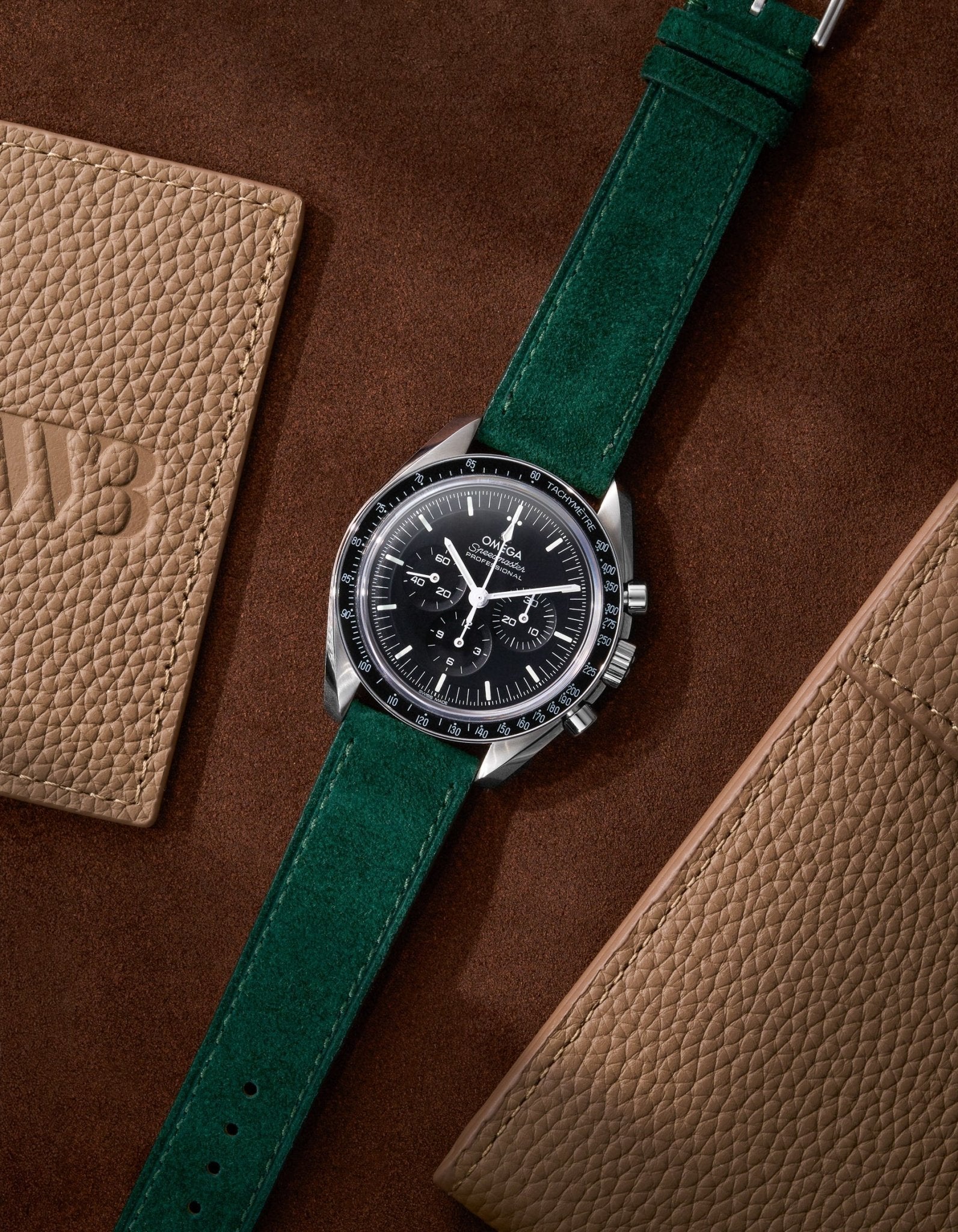 Dark Green Suede Leather Strap 17mm - 21mm on Speedmaster flat lay on brown background