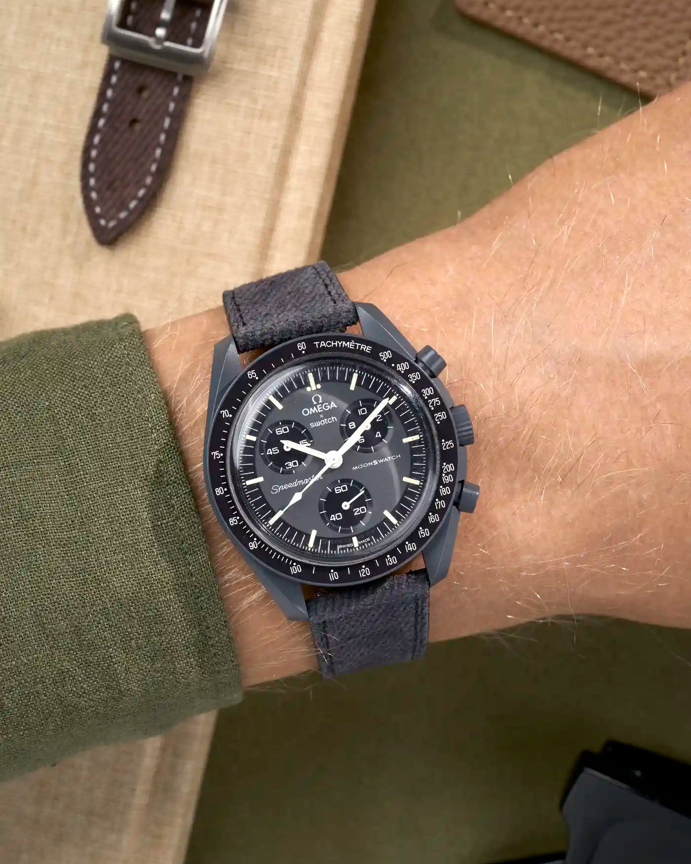 Dark grey denim watch strap on Omega x Swatch Mission to Mercury shown on wrist, styled with quick-release function