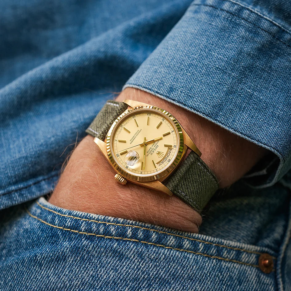 Lifestyle image of denim watch strap on wrist – soft leather-lined strap styled with gold watch and denim shirt