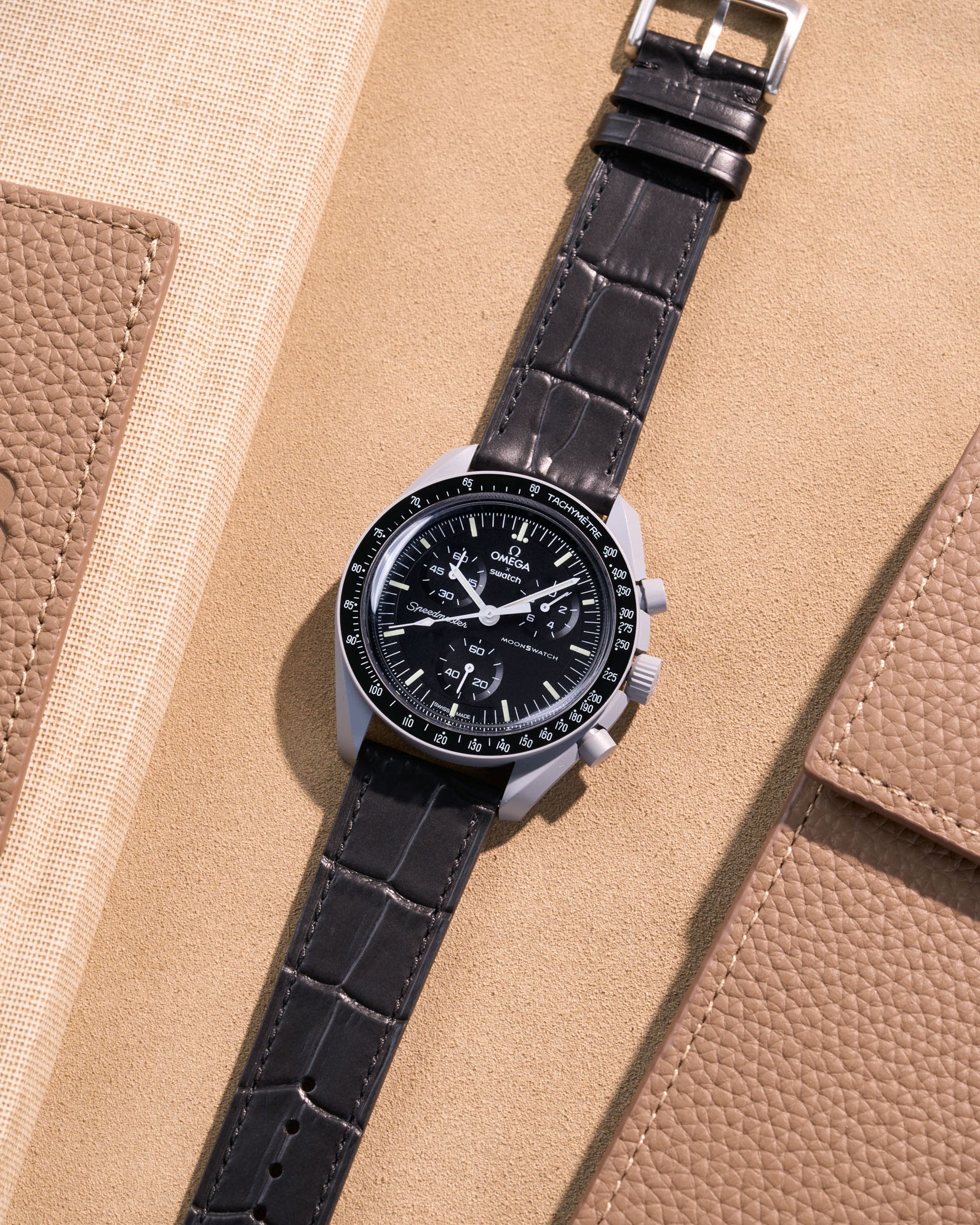 Flat lay of Omega X Swatch MoonSwatch Mission to the Moon with black embossed alligator leather strap