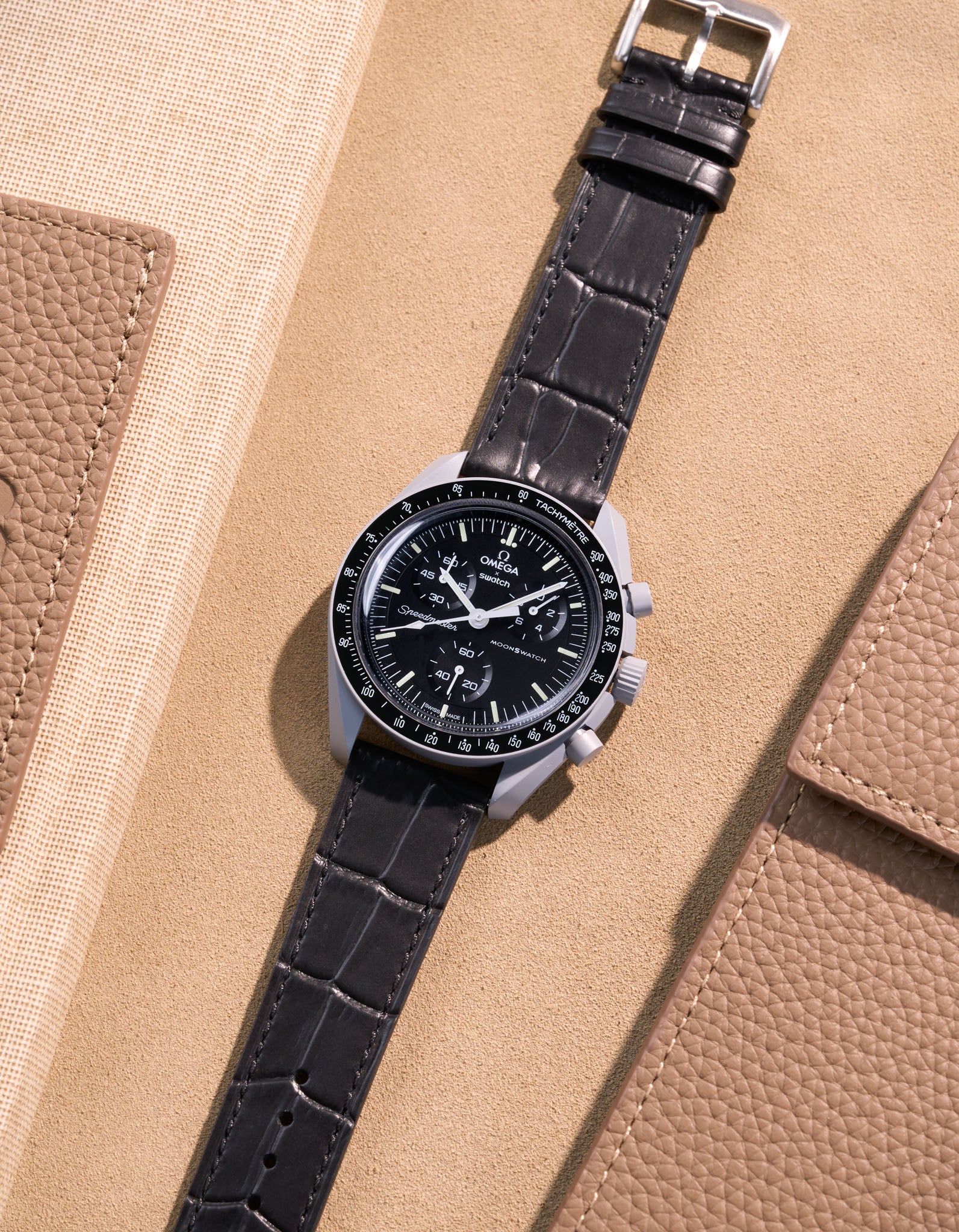 Flat lay of Omega X Swatch MoonSwatch Mission to the Moon with black embossed alligator leather strap