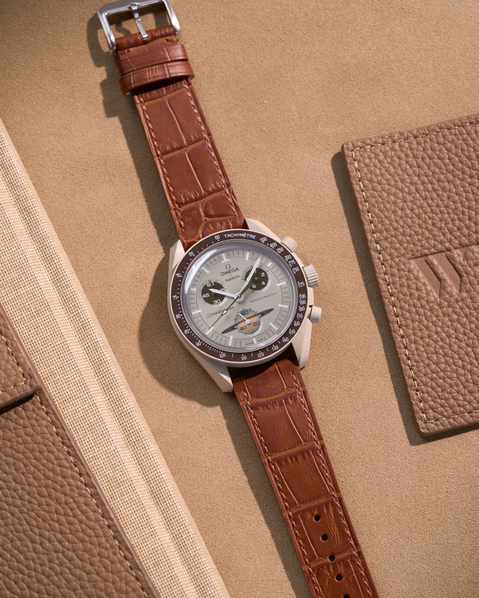Flat lay of Omega X Swatch MoonSwatch Mission to Saturn with light brown embossed alligator leather strap