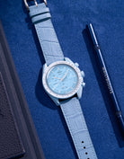 Flat lay of Omega X Swatch MoonSwatch mission to Uranus  with sky blue embossed alligator leather strap