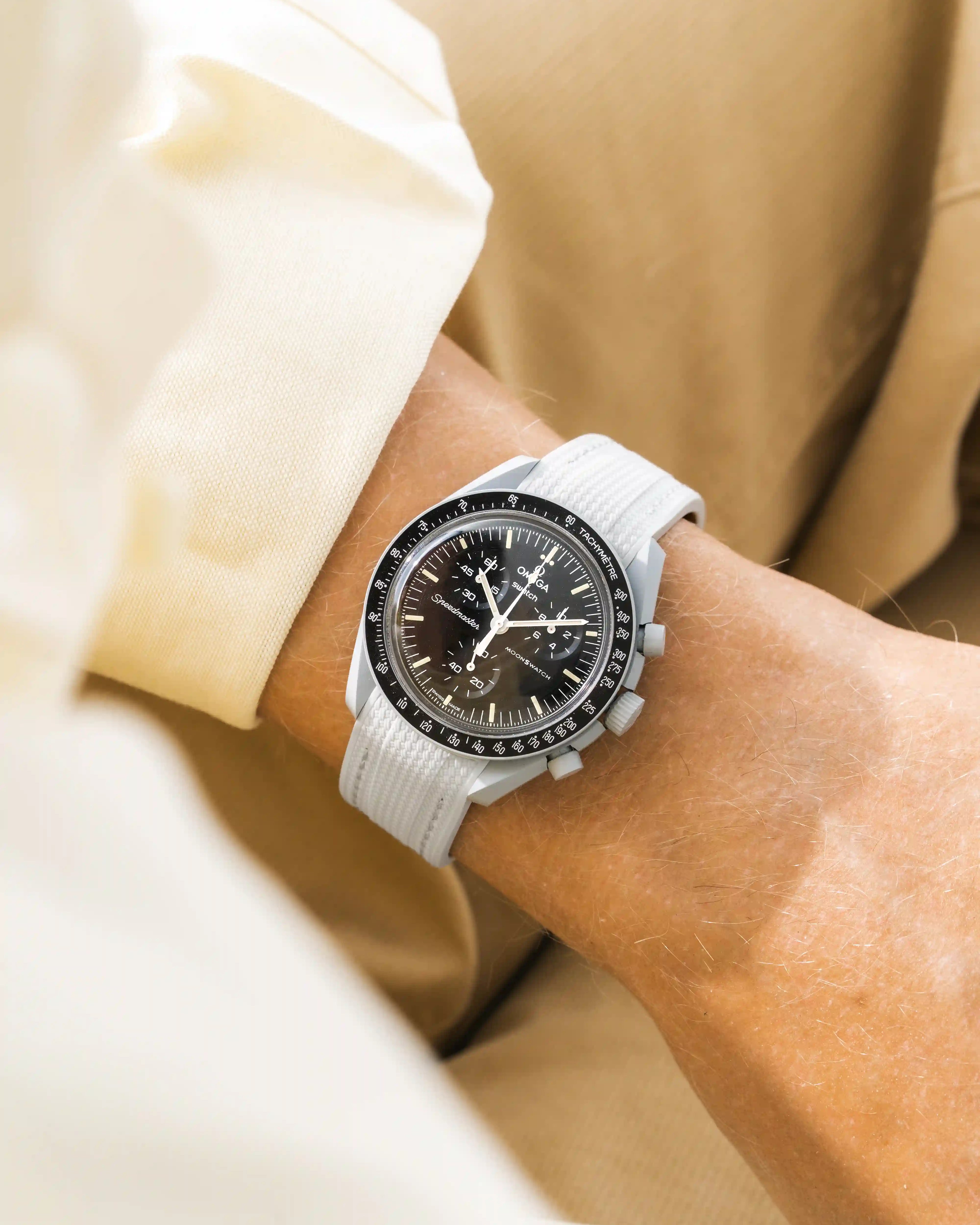 Grey rubber strap for Omega MoonSwatch Mission to the Moon – wrist shot with beige outfit