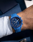 Blue and white rubber strap for Omega MoonSwatch, shown on wrist with matching blue case and dial