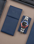 Navy blue leather watch pouch by Wristbuddys with Rolex GMT-Master Pepsi resting on pouch lid – luxury travel case for watches