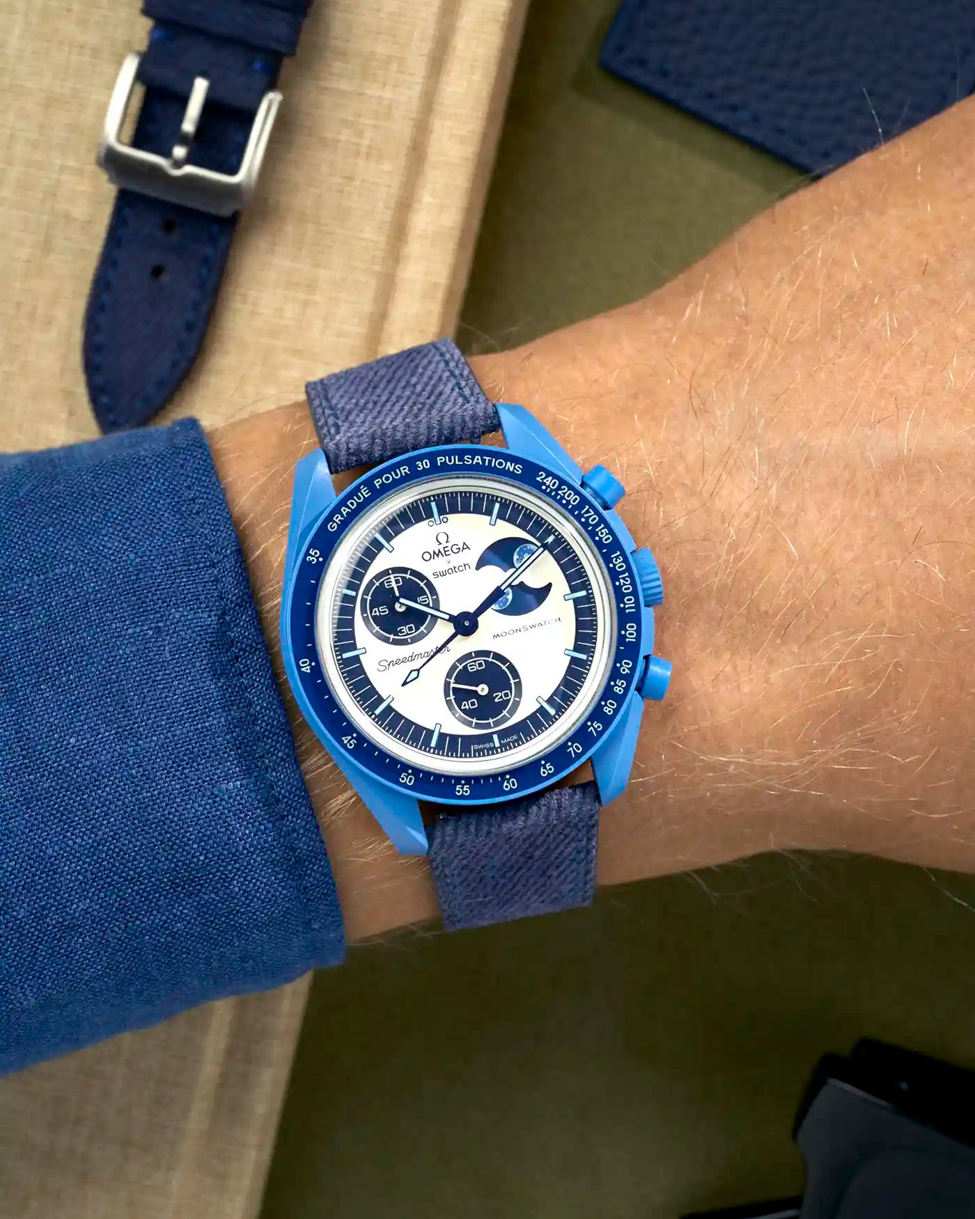 Omega X Swatch Mission to Super Blue Moonphase on blue denim strap with matching blue stitching – wrist shot