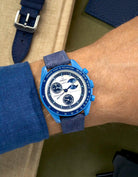 Omega X Swatch Mission to Super Blue Moonphase on blue denim strap with matching blue stitching – wrist shot
