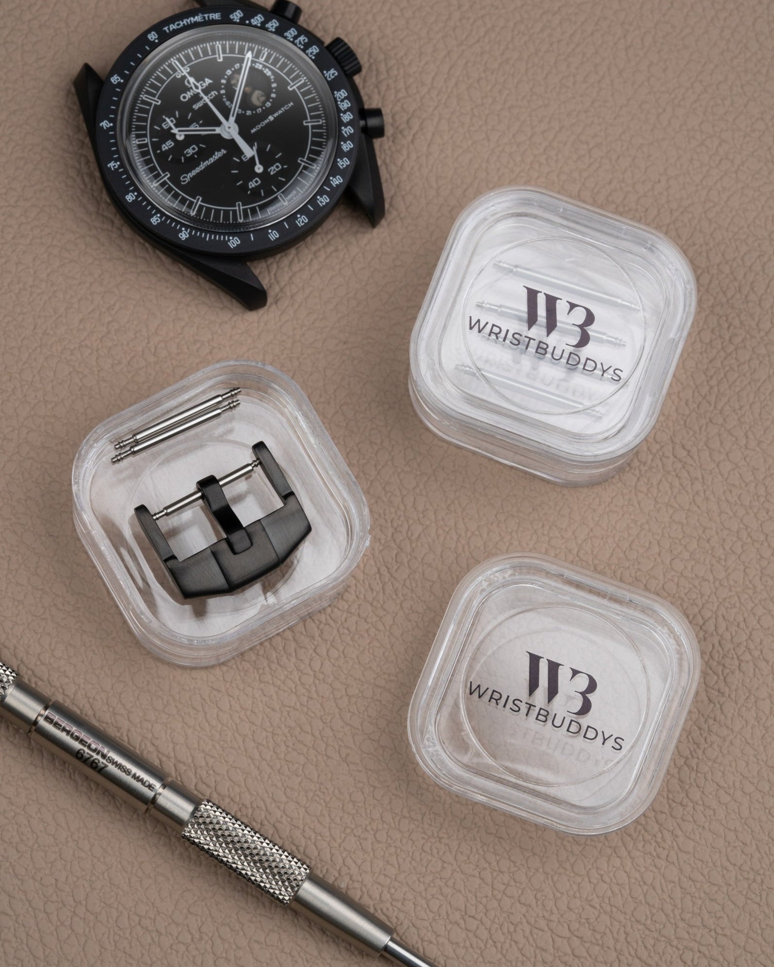 Premium buckle in black for watch straps, shown with spring bars and Wristbuddys tool