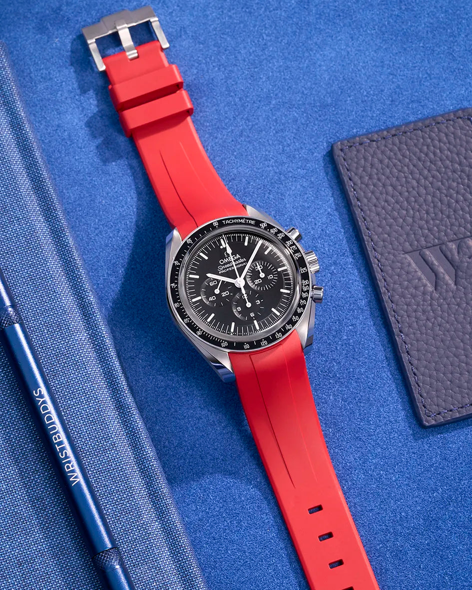 Red FKM rubber strap on Omega Speedmaster – flat lay with stainless steel clasp visible