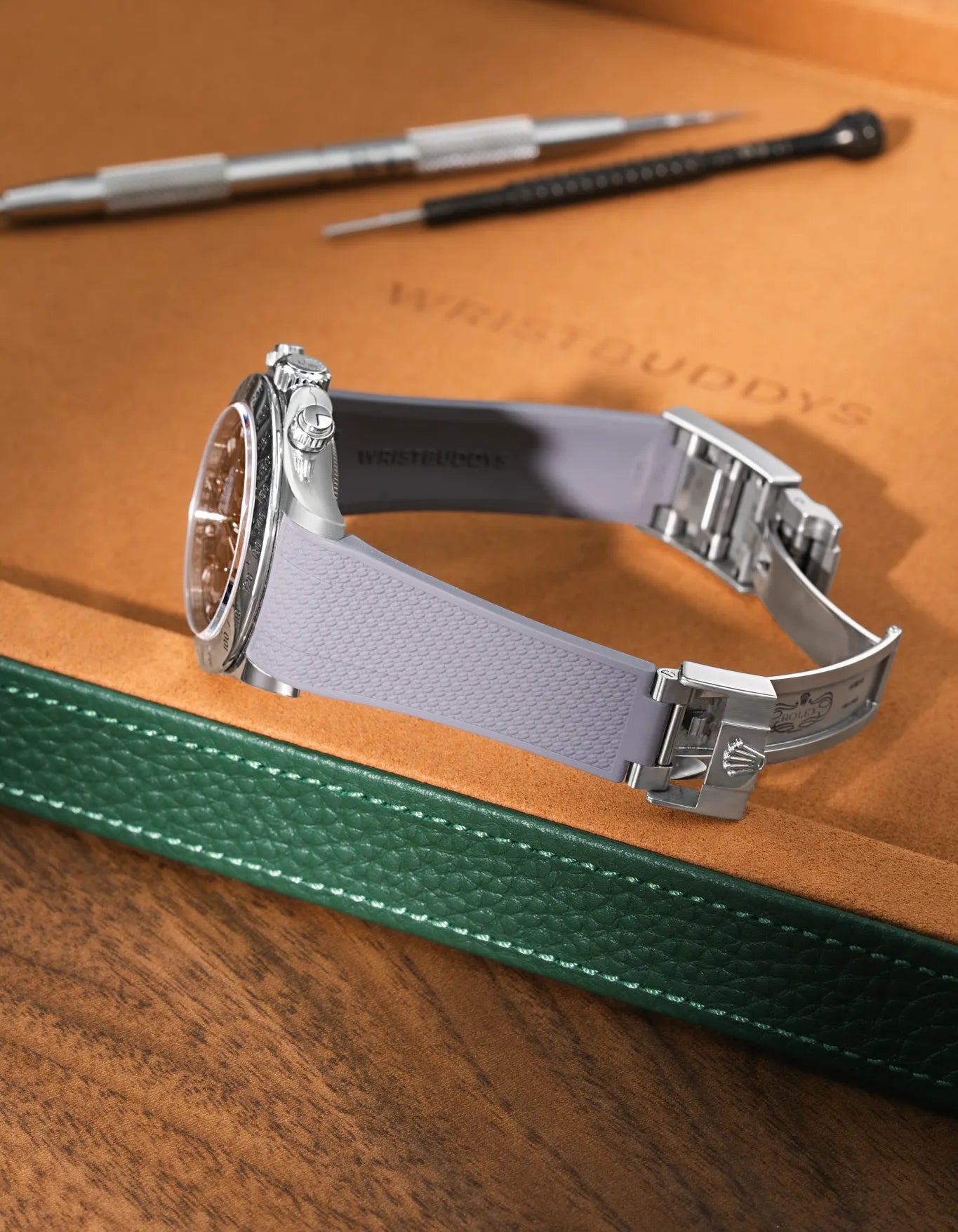 Grey Vertech FKM rubber watch band for Rolex Daytona 116520, premium integrated replacement strap with original clasp on a leather tray.