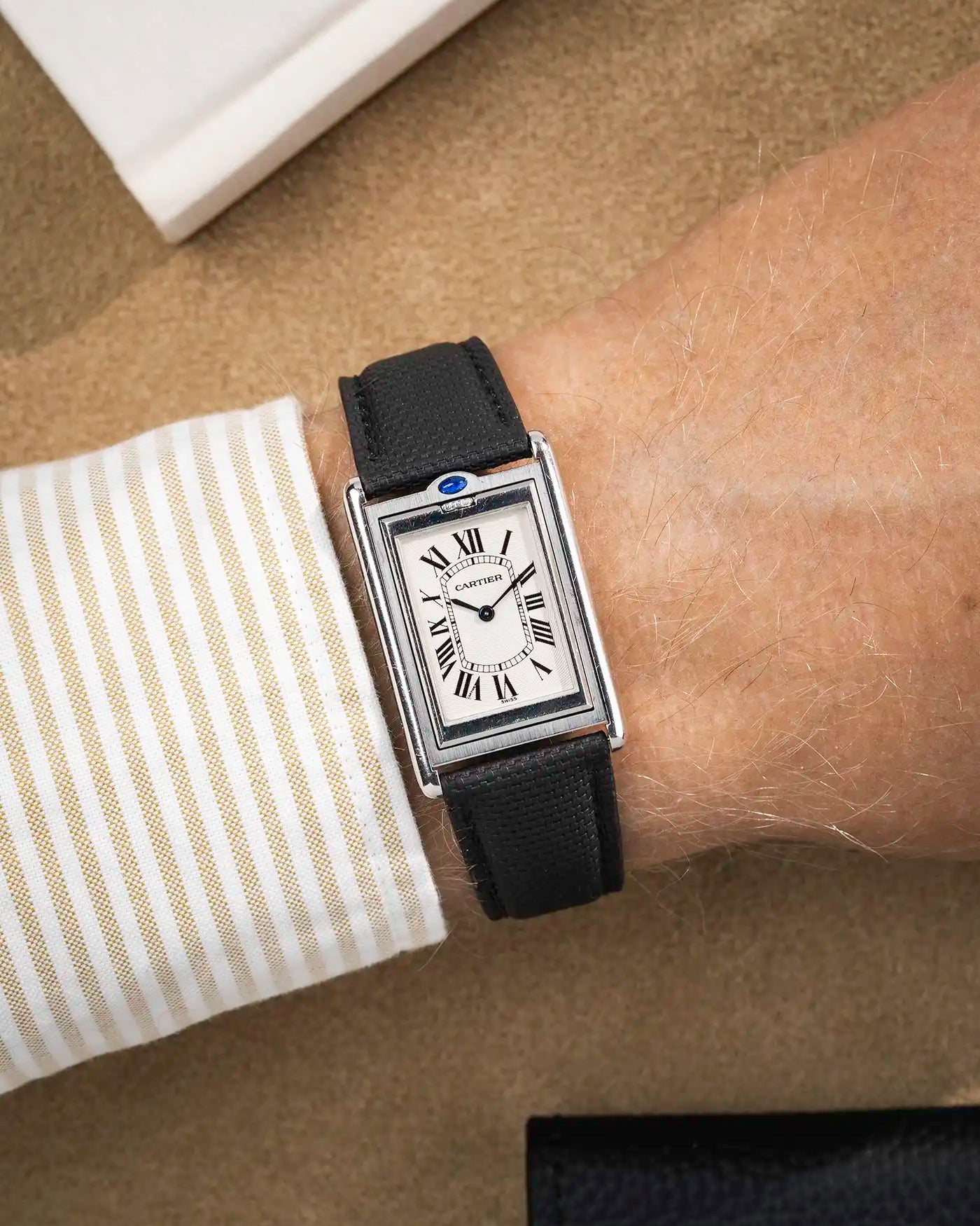 Sailcloth textured rubber strap worn with rectangular white dial watch – refined look for formal occasions