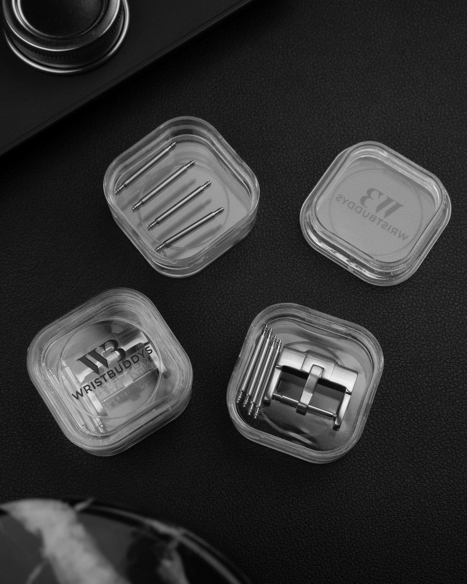 Silver standard watch strap buckle and spring bars in Wristbuddys packaging black background