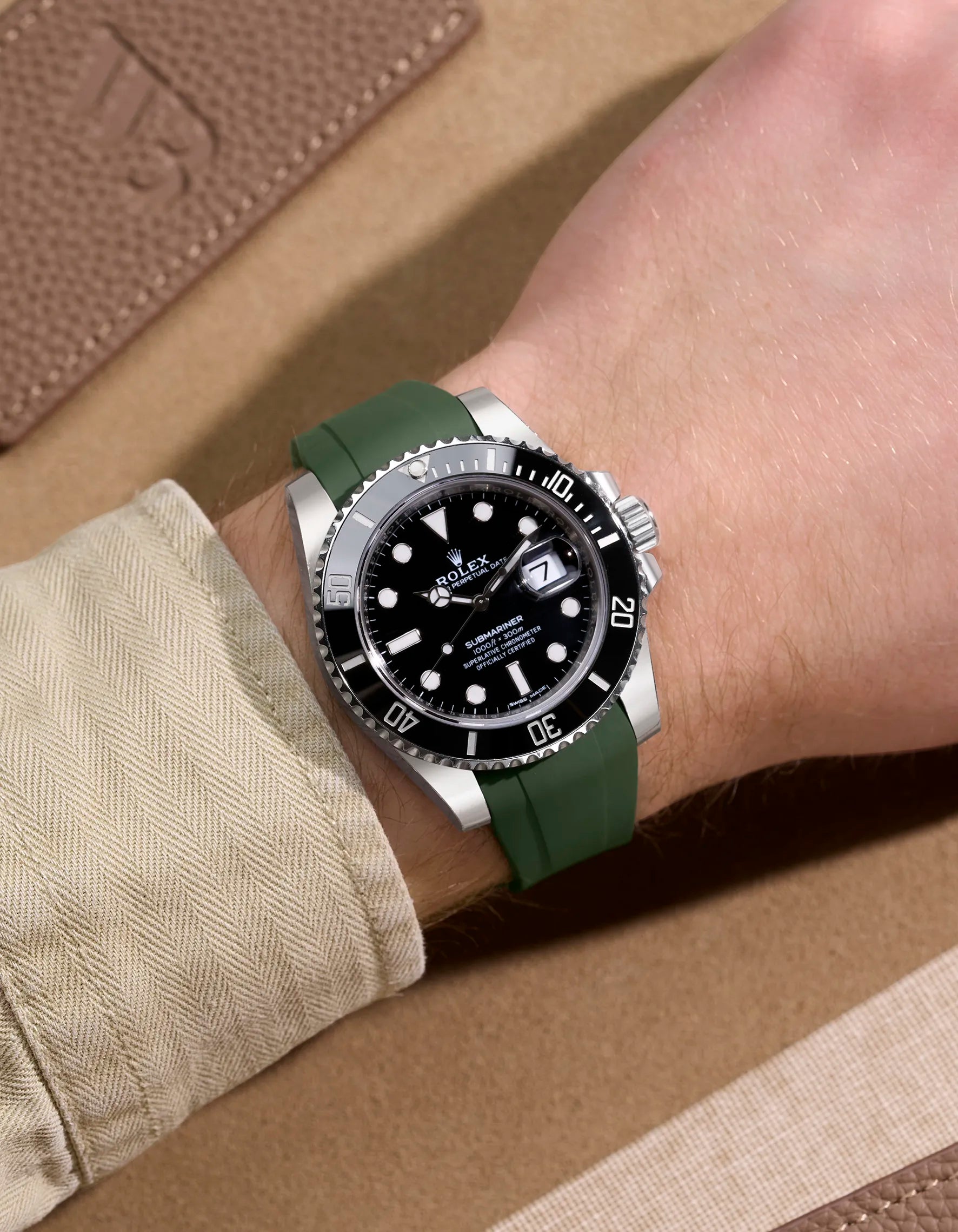 Green rubber strap fitted on Rolex Submariner 114060LN shown on wrist in lifestyle setting