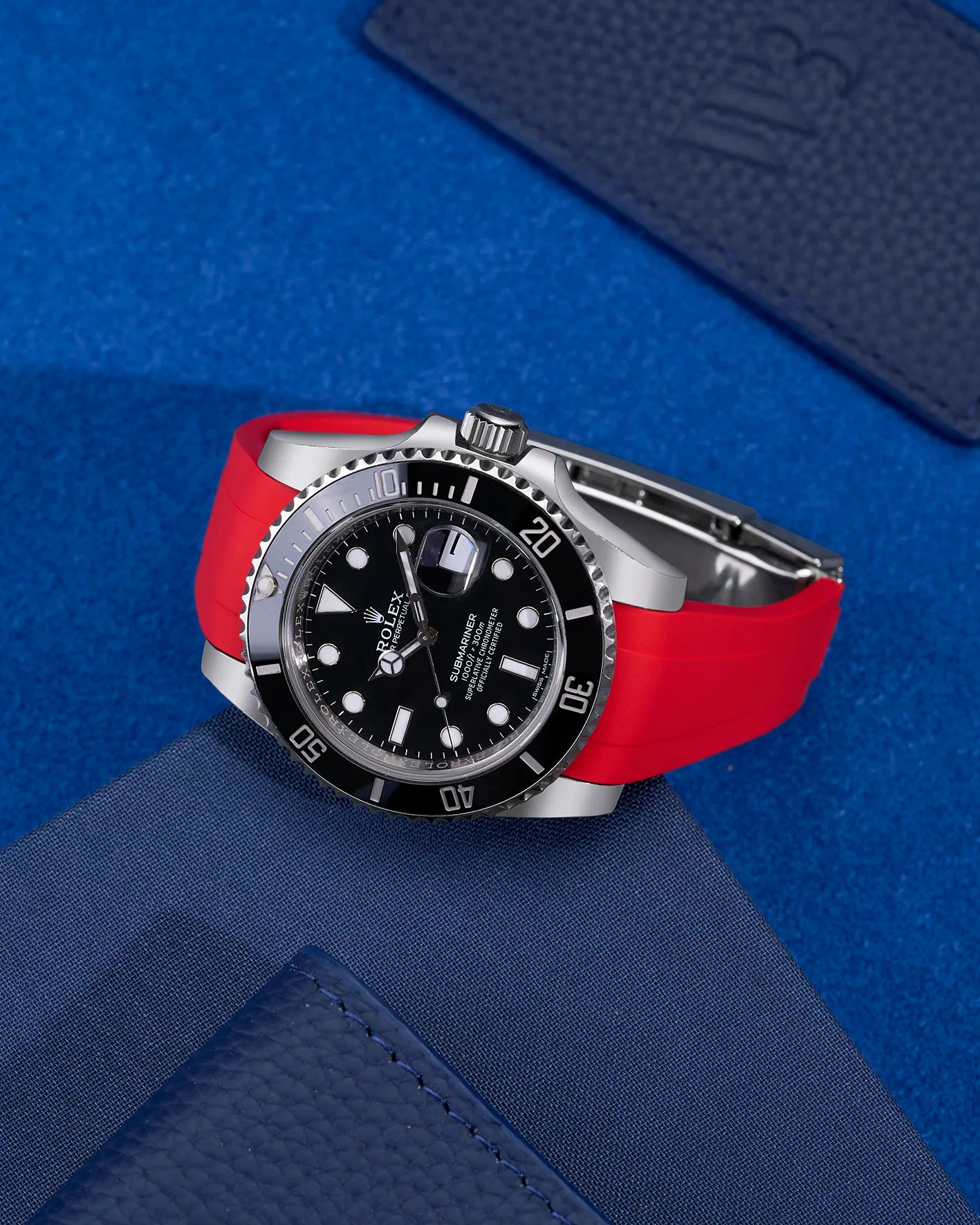 Rolex Submariner with red FKM rubber strap integrated with original clasp, flat lay view on blue background – fits 116610LN and 114060LN