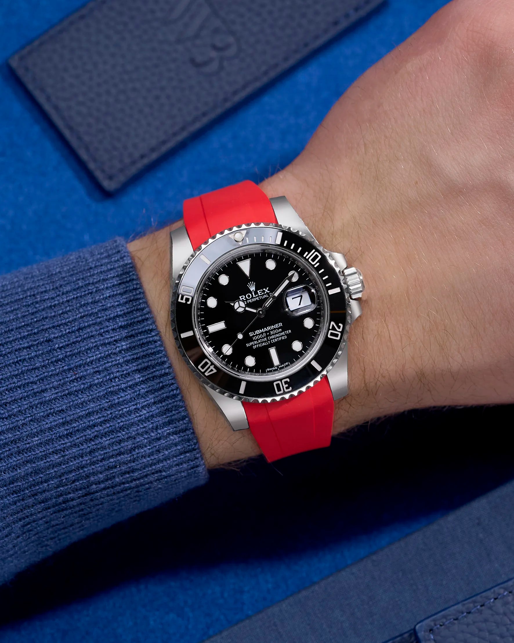Rolex Submariner 116610LN or 114060LN with red integrated rubber strap on wrist, paired with original clasp