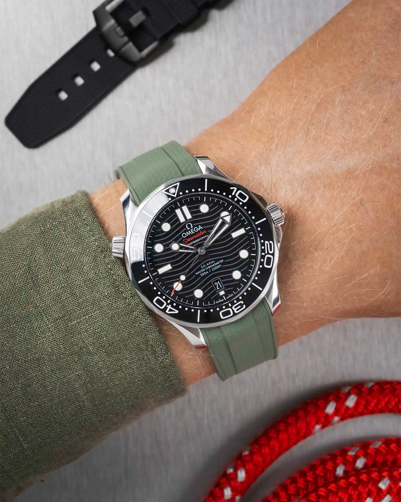 Omega Seamaster 300 Diver with black dial on wrist, paired with dark green Vertech FKM rubber strap