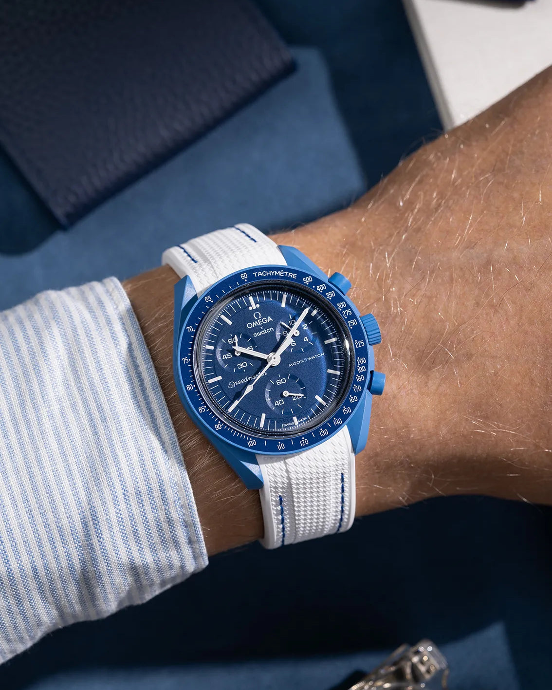White curved rubber strap with blue stitching for Omega MoonSwatch, shown on wrist with Vertech textured finish