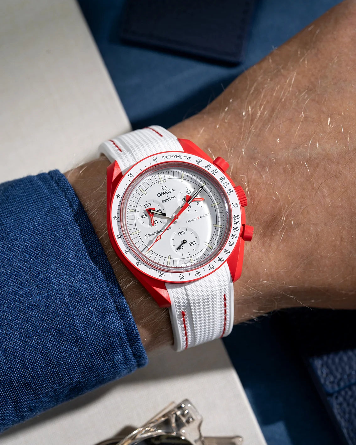 Wrist shot showing white rubber strap with red stitching for Omega X Swatch MoonSwatch Mission to Mars