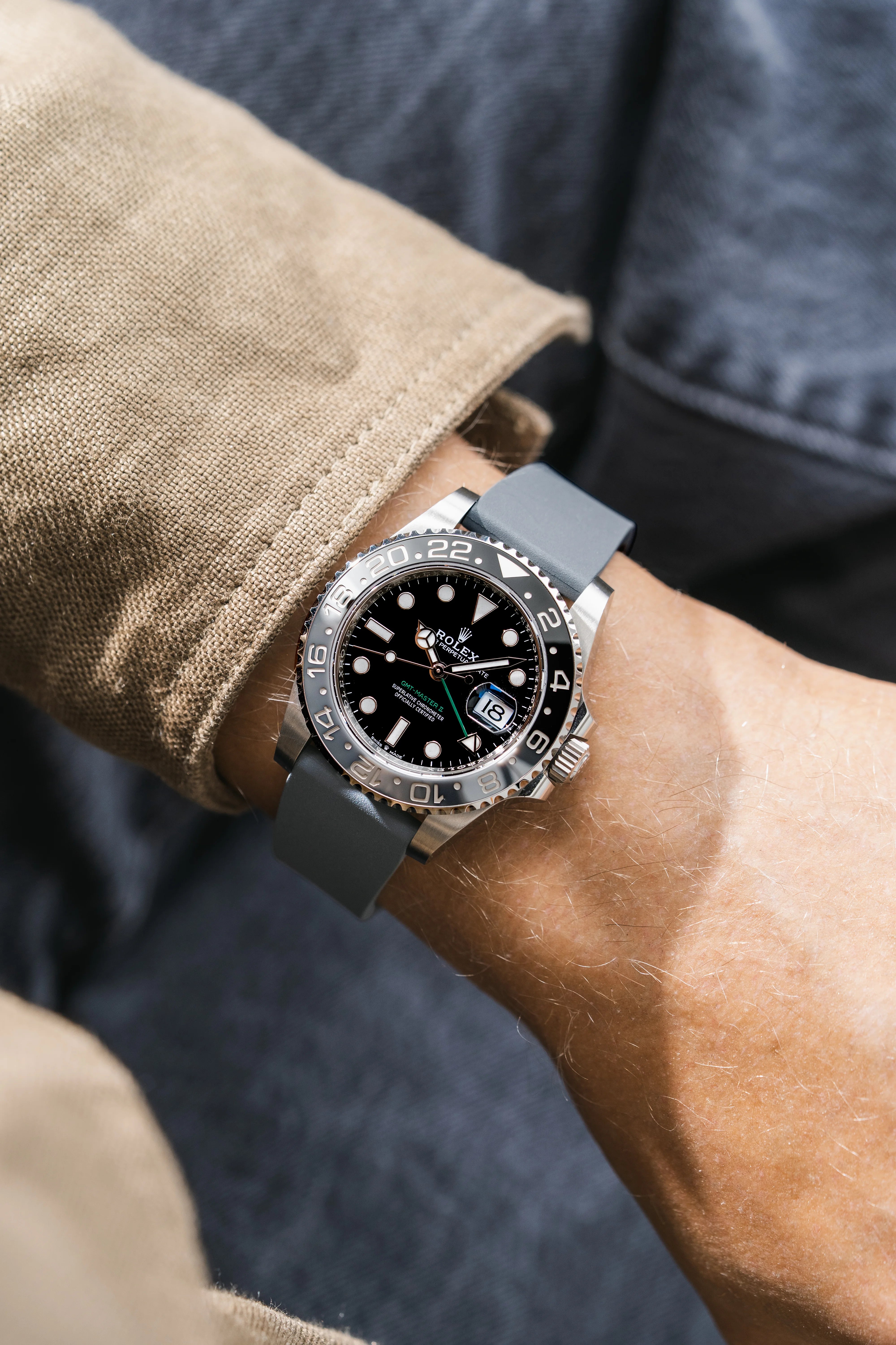 Close-up of a wrist wearing a Rolex GMT Master 2 with a grey CTS Rubber strap from Wristbuddys with a black face and gray strap.