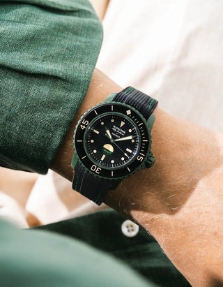 Black Vertech rubber strap with green stitching for Blancpain x Swatch Scuba Fifty Fathoms Green Abyss – worn on wrist with dark green linen shirt, black dial and black bezel with green case, side angle view